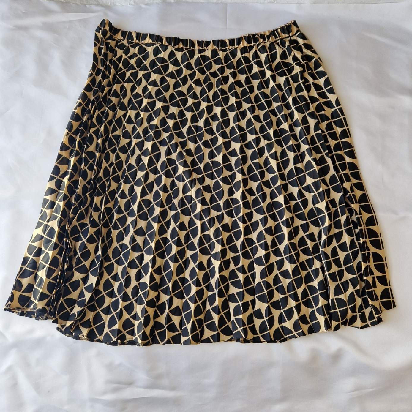 A knee-length, high-rise A-line skirt by George featuring a black and metallic gold geometric print.