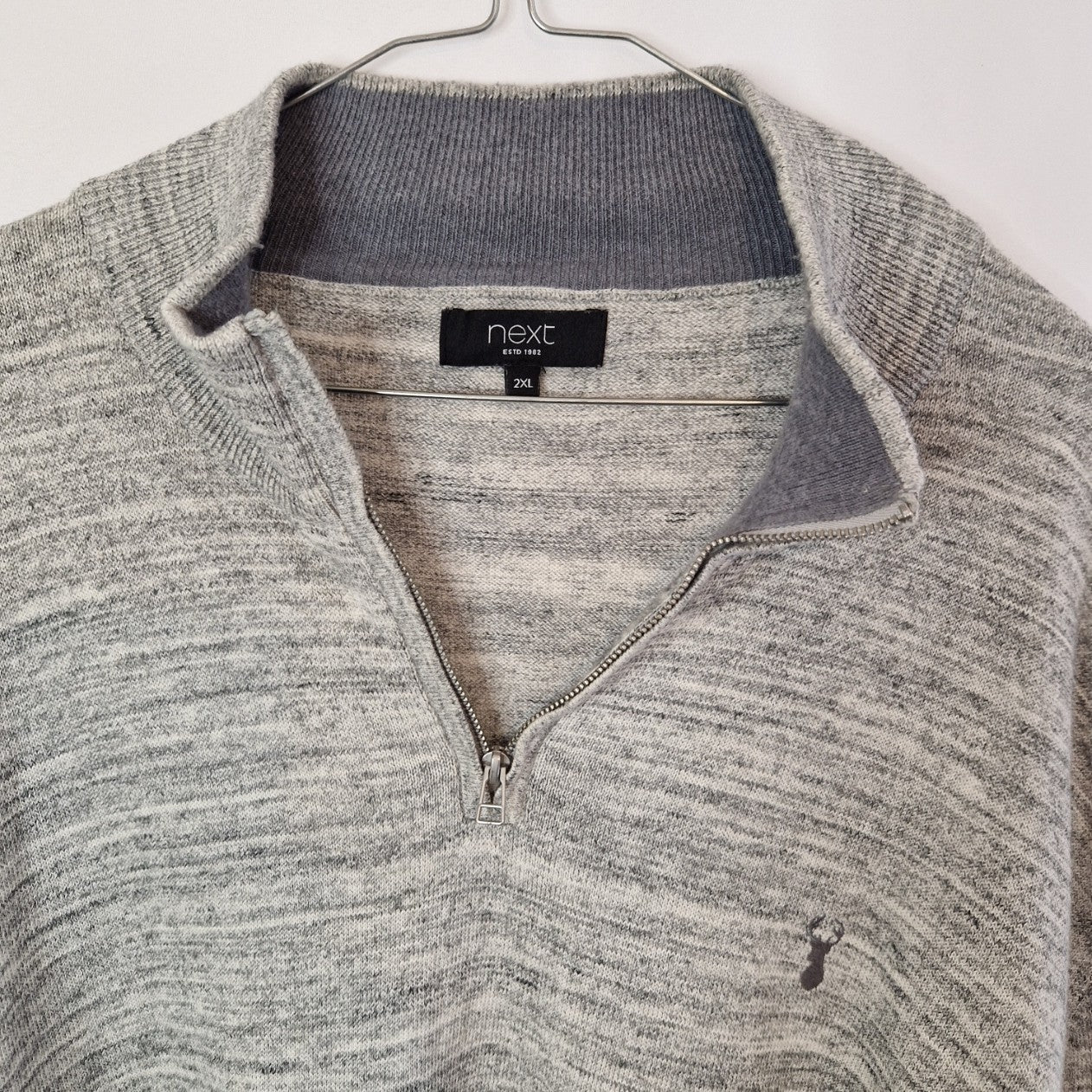 A grey Next quarter-zip knit jumper with a small embroidered stag logo on the chest.