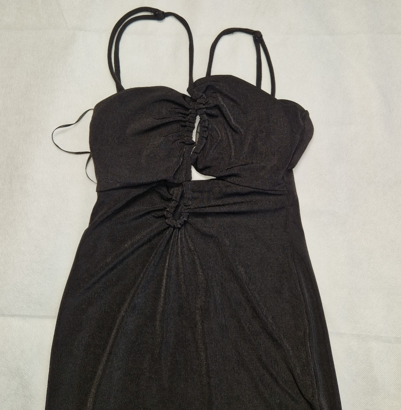 A black Bershka crop top featuring padded cups, thin straps, and a gathered cutout design.