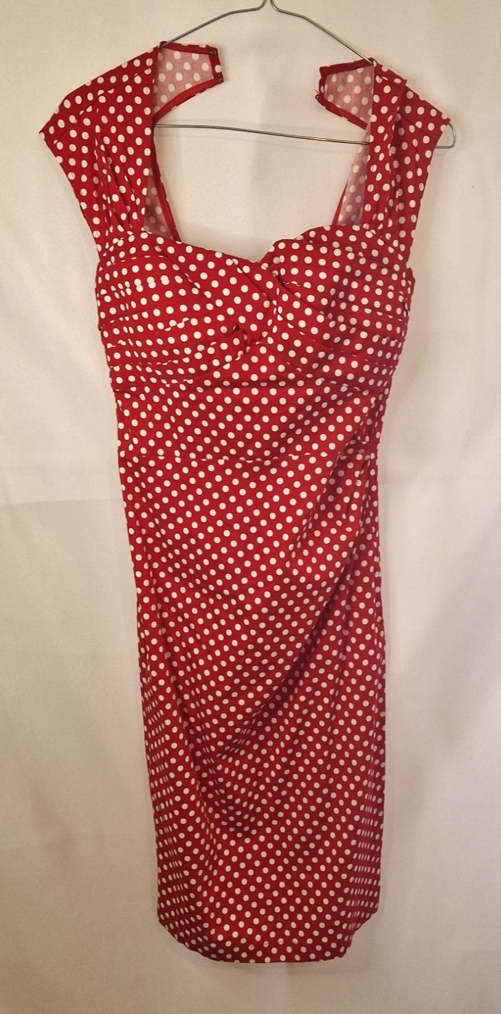 A red knee-length halter dress featuring a white polka dot pattern and a fitted bodice.