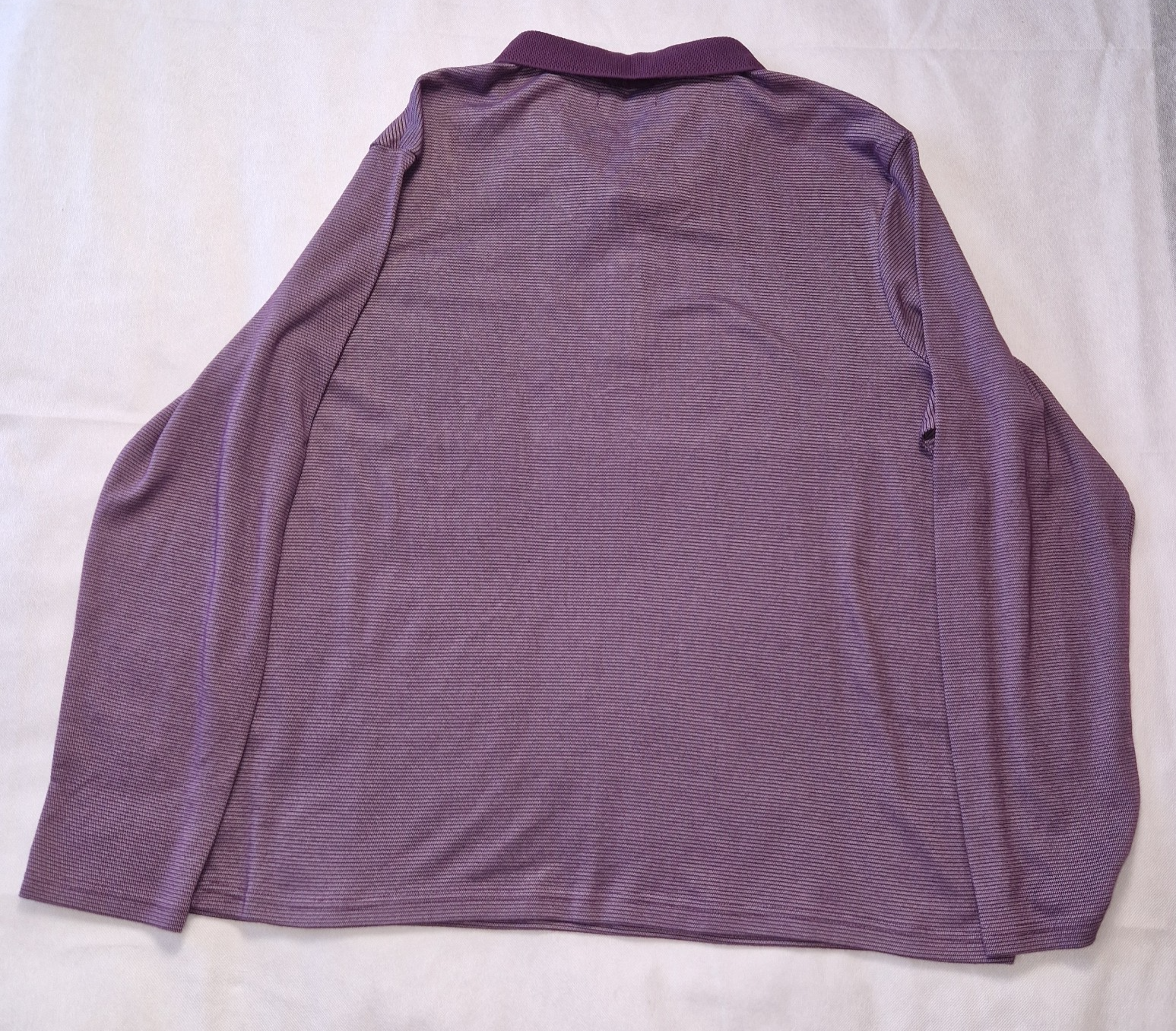 A purple long-sleeved pullover sweatshirt with a textured finish and a round collar.