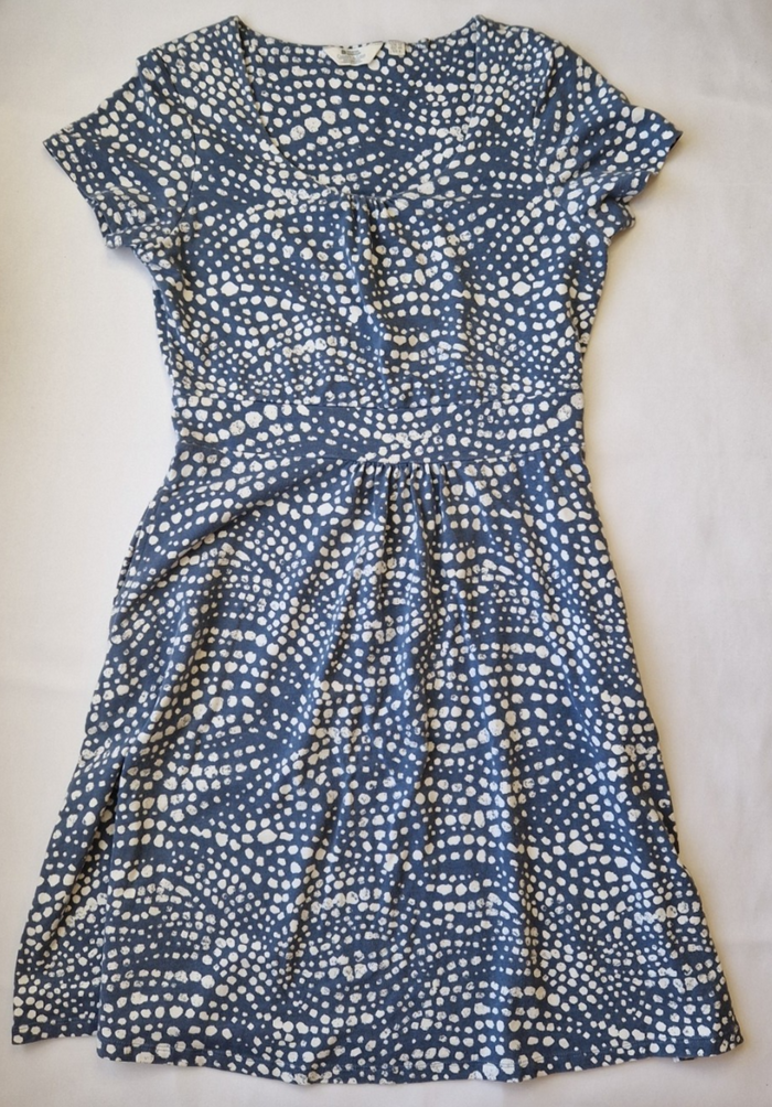 A blue knee-length fit and flare dress with a white polka dot pattern and short cap sleeves.