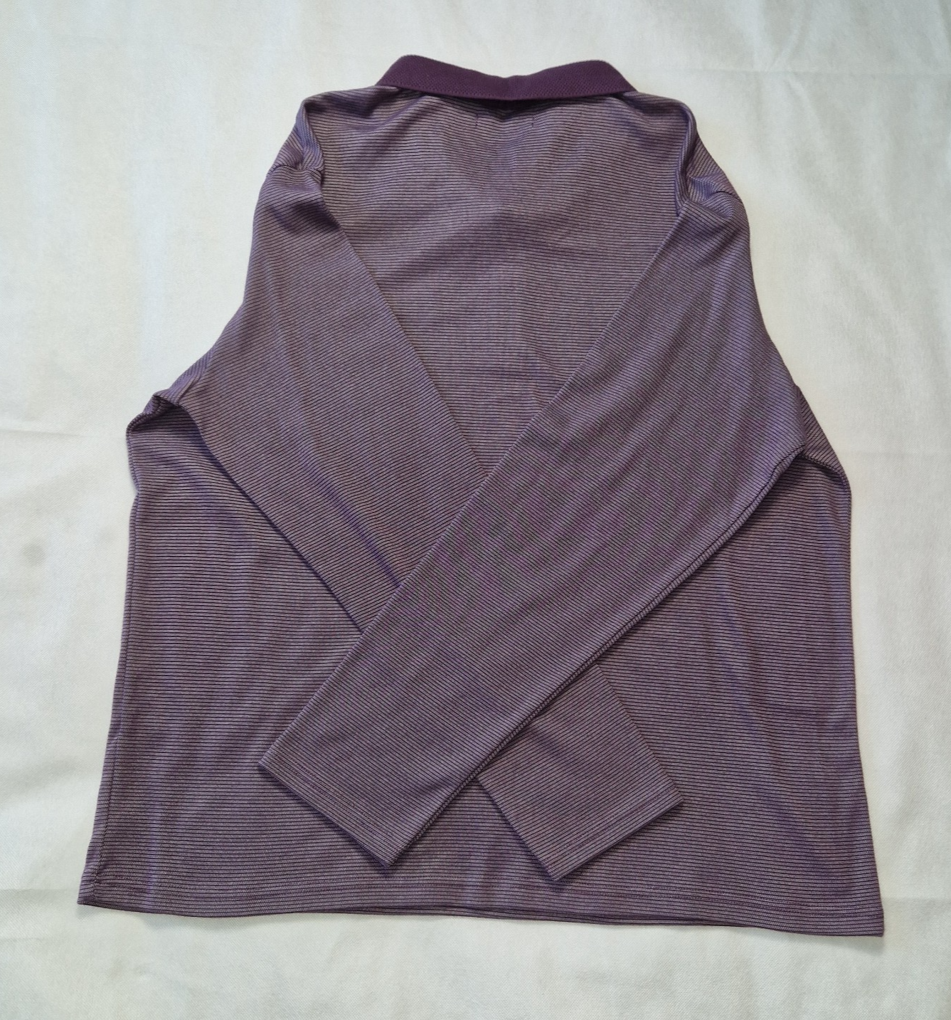 A purple long-sleeved pullover sweatshirt with a round neck in a soft cotton blend fabric.