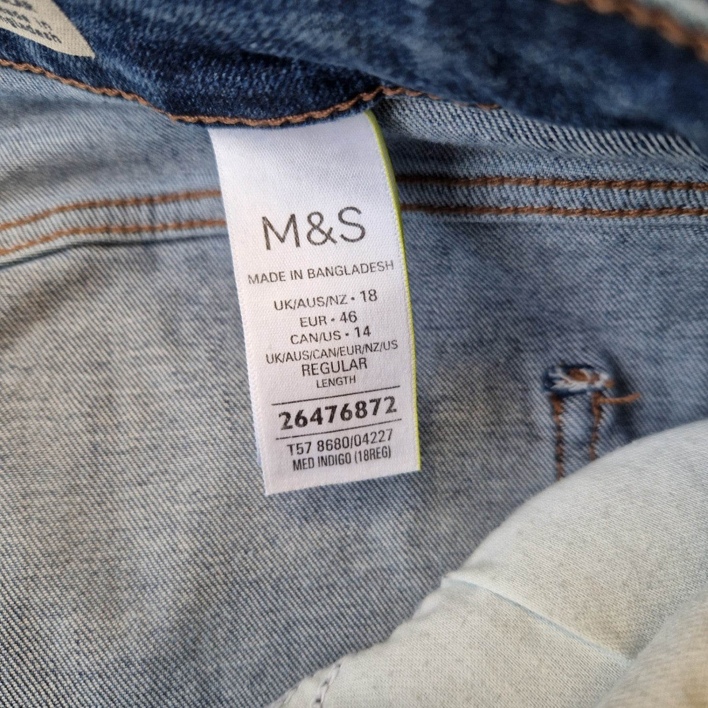 A close-up of the interior care label on a pair of Marks and Spencer blue denim jeans.