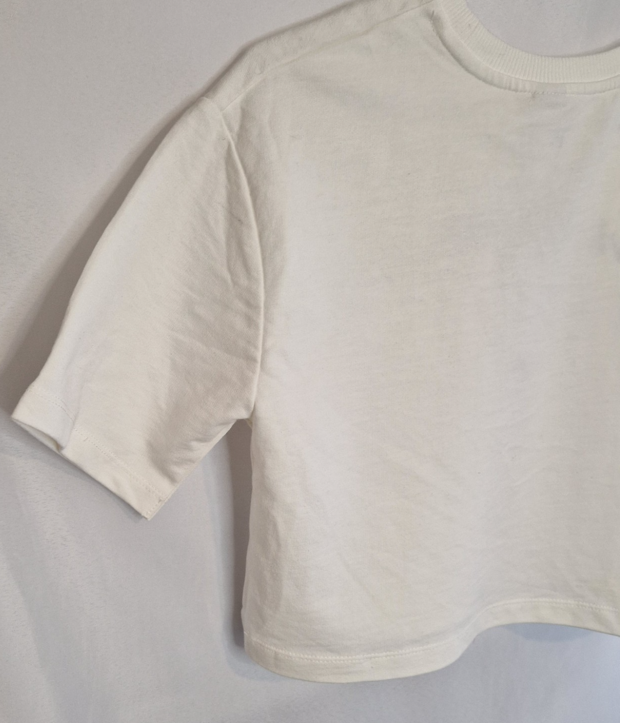 A plain white short-sleeved toddler t-shirt with a round neckline.