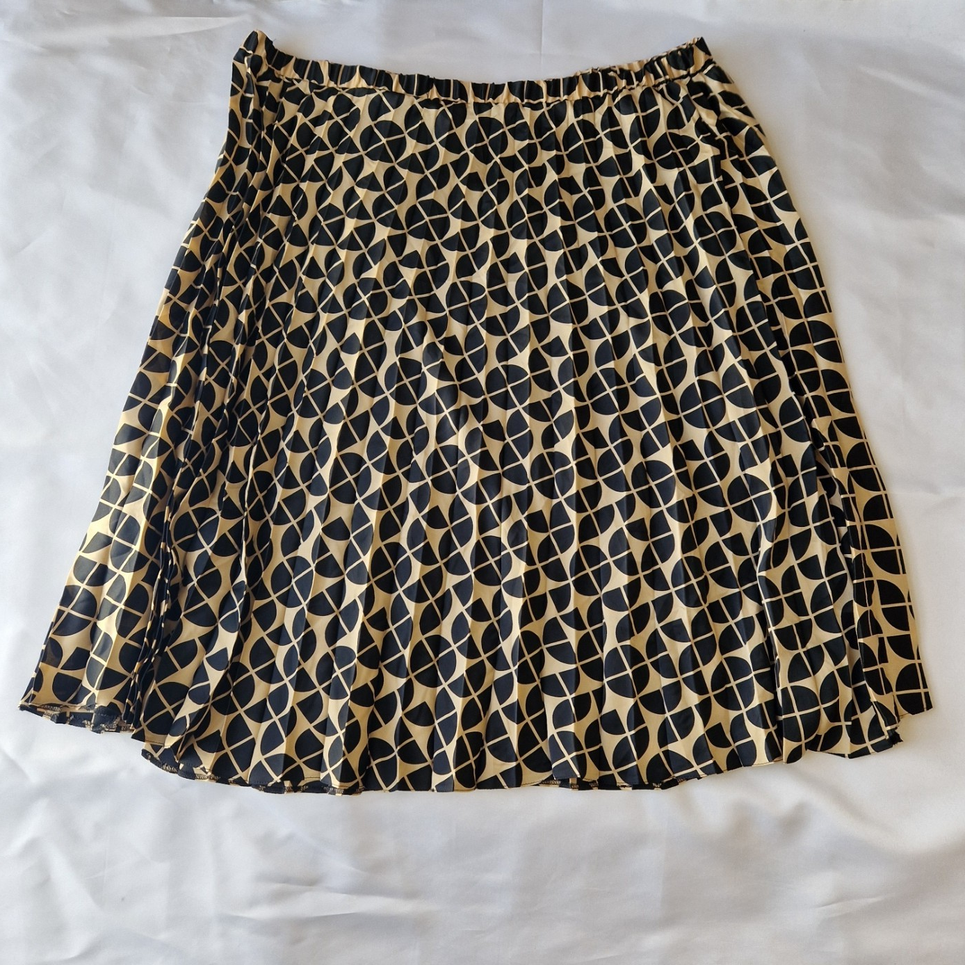 A knee-length, high-rise A-line skirt by George in a metallic gold and black geometric print.