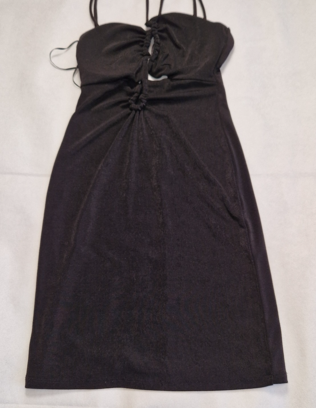 A black Bershka off-shoulder crop top with thin straps and a gathered front detail.