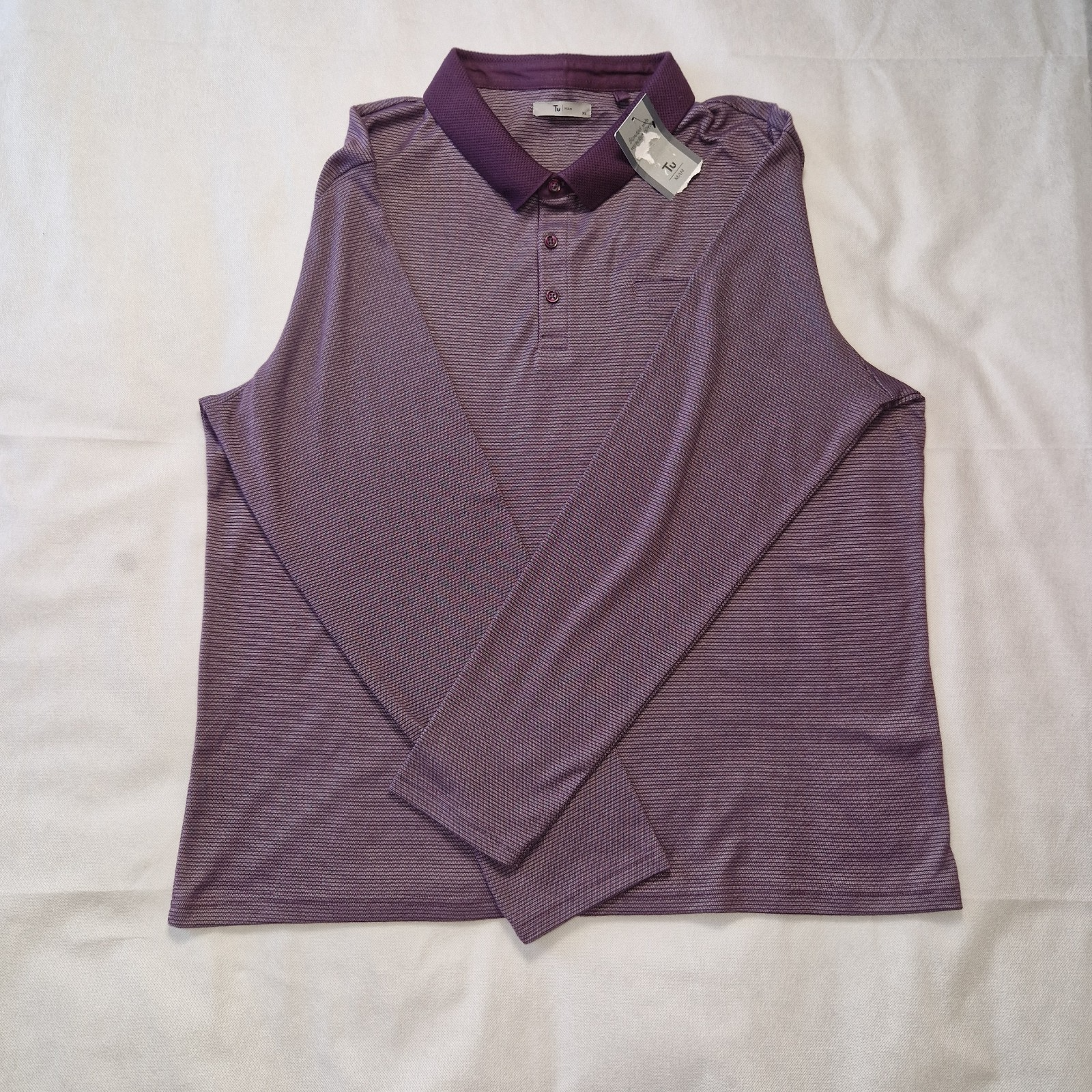 A purple long-sleeved polo shirt with a textured collar and button placket.