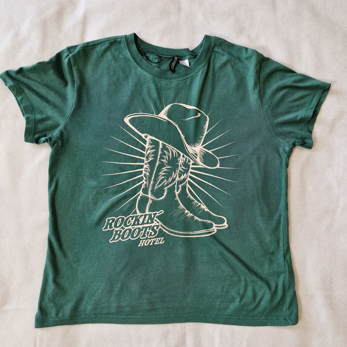 A green H&M Divided cotton t-shirt featuring a graphic of a cowboy hat and boots.