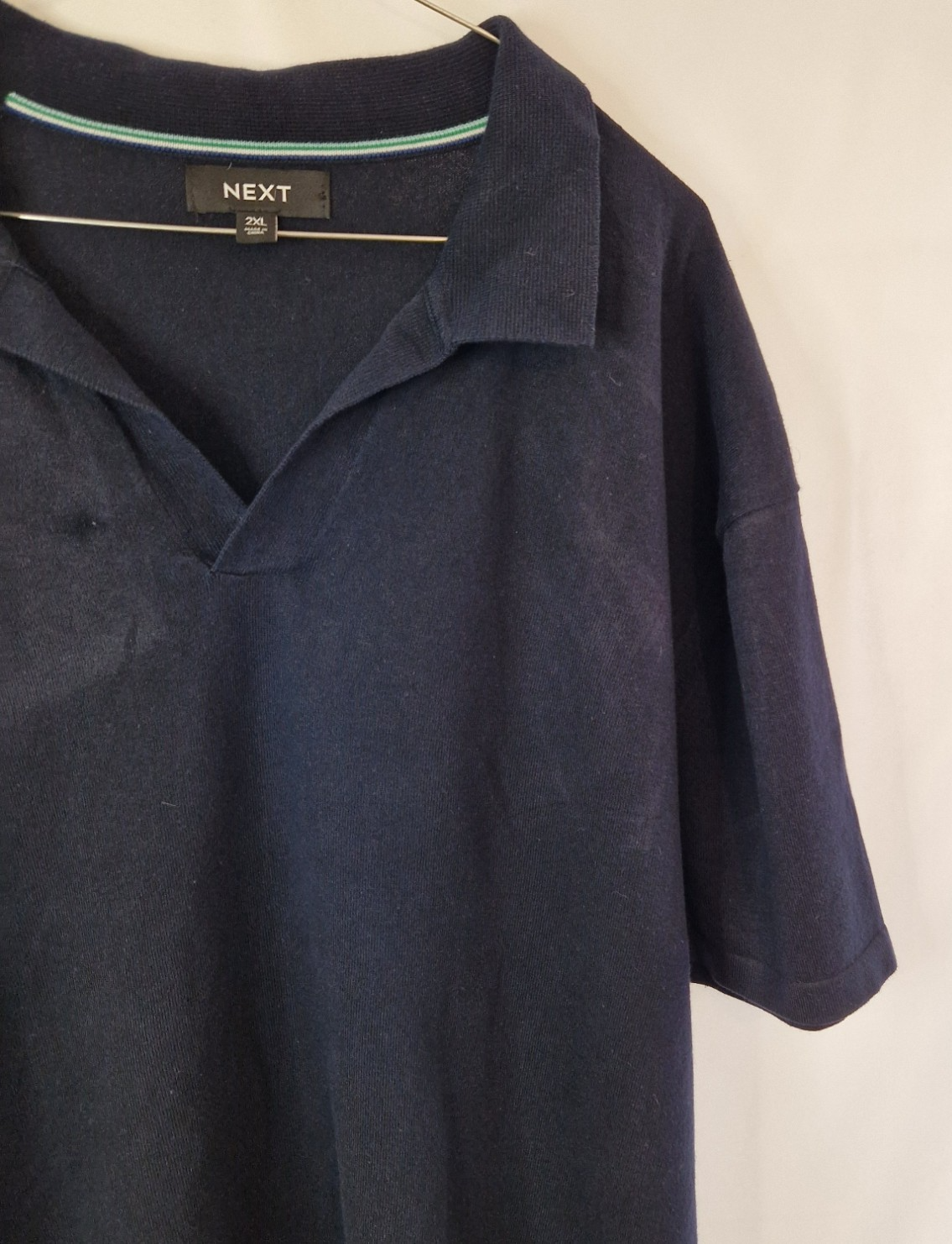 A dark blue Next short-sleeve cotton polo shirt featuring a V-neck collar.