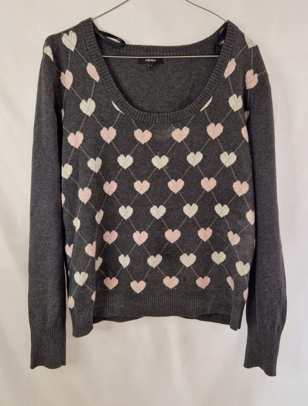 A grey Papaya long-sleeve jumper featuring a repeating white and pink heart argyle pattern.