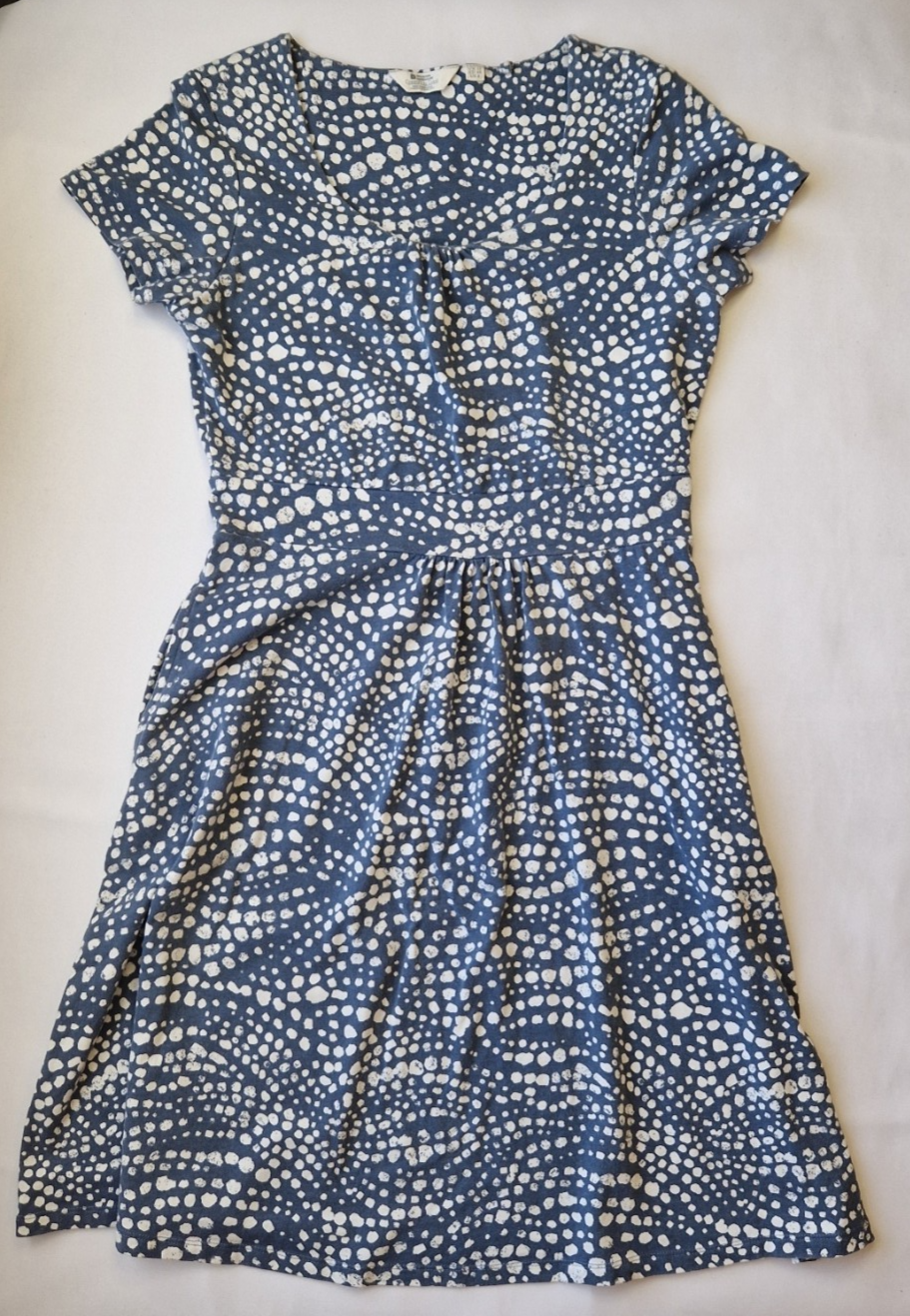 A blue knee-length fit and flare dress with a white polka dot pattern and short cap sleeves.
