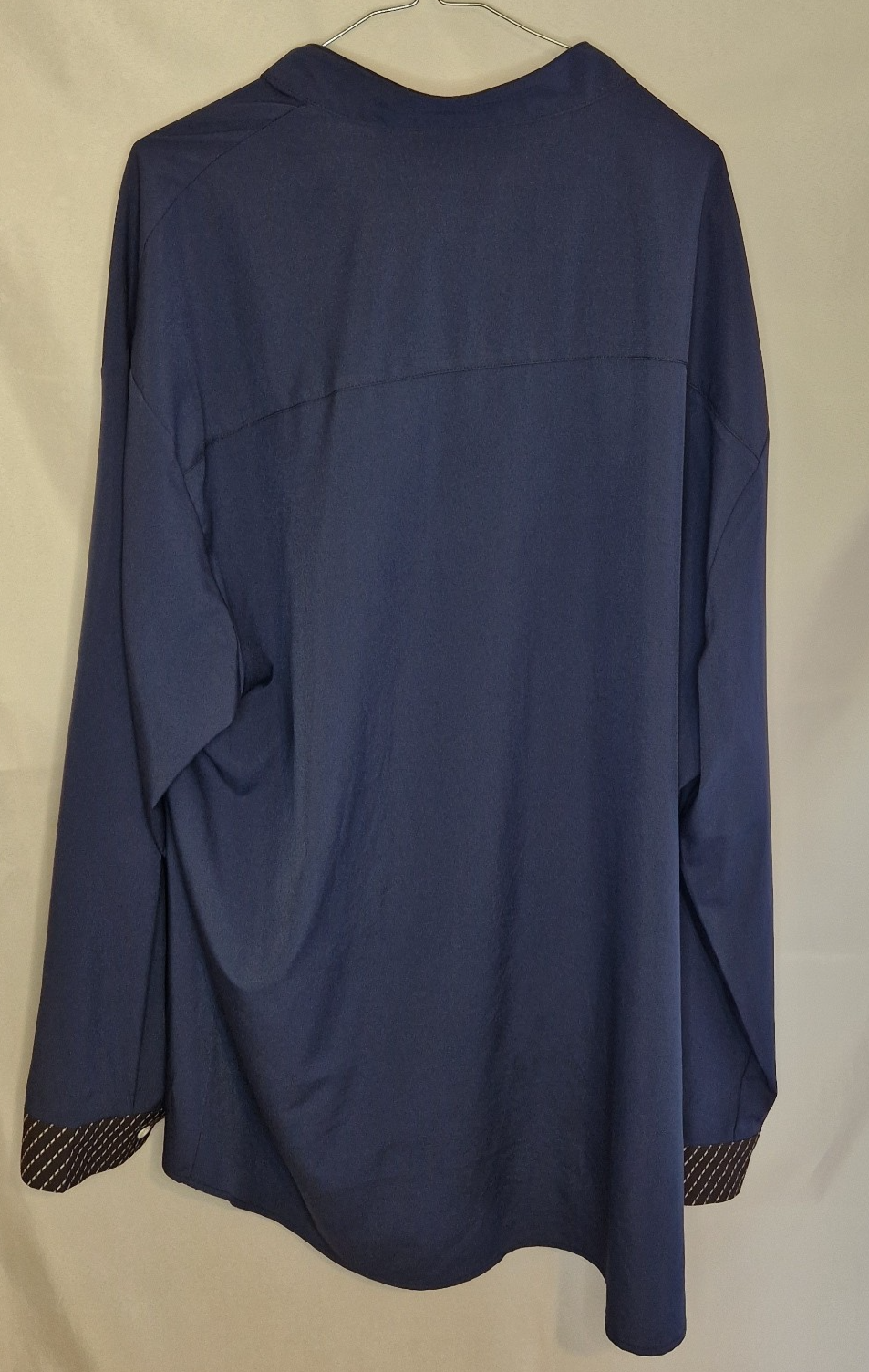 A blue long-sleeve men's shirt in a satin finish with patterned contrast trim on the cuffs.
