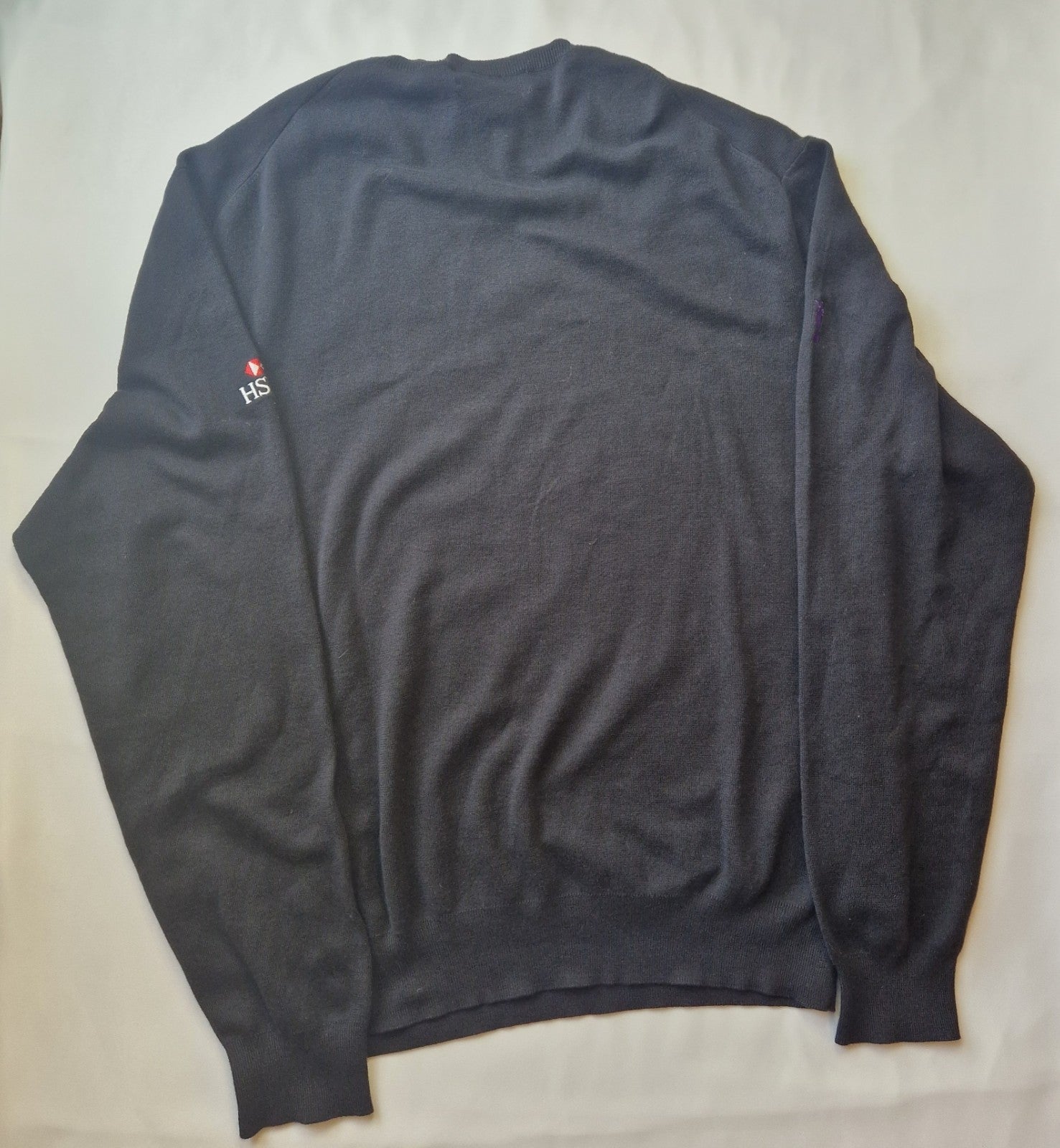 A black Ralph Lauren V-neck cotton sweater featuring an embroidered HSBC logo on the sleeve.