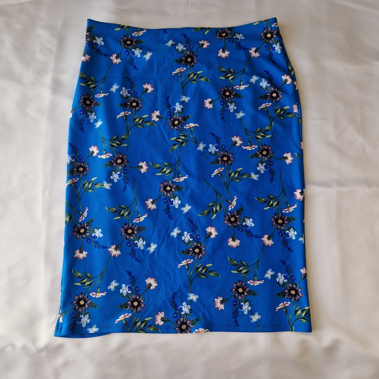 A blue knee-length wrap skirt in stretch jersey featuring a floral print pattern.