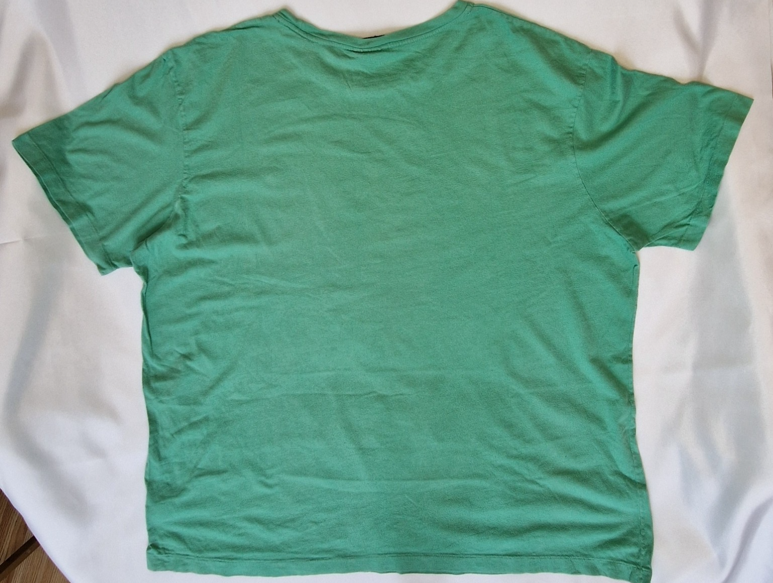 A plain green short-sleeved cotton t-shirt with a round neckline.