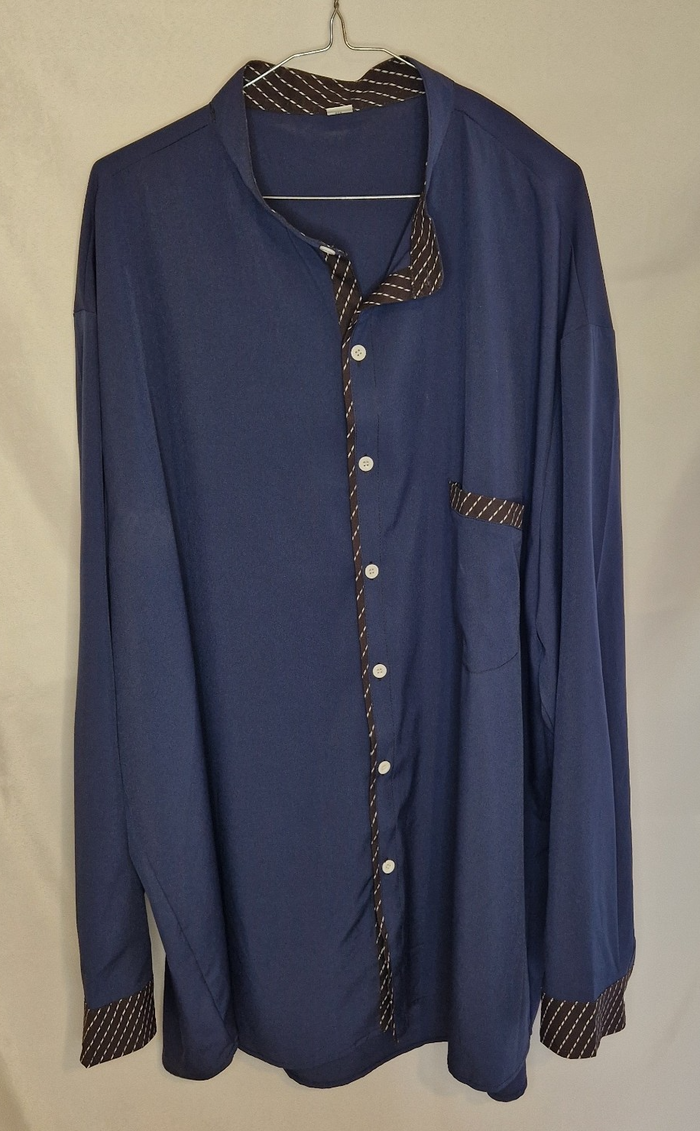 A blue long-sleeve satin shirt featuring a brown and white patterned contrast trim.