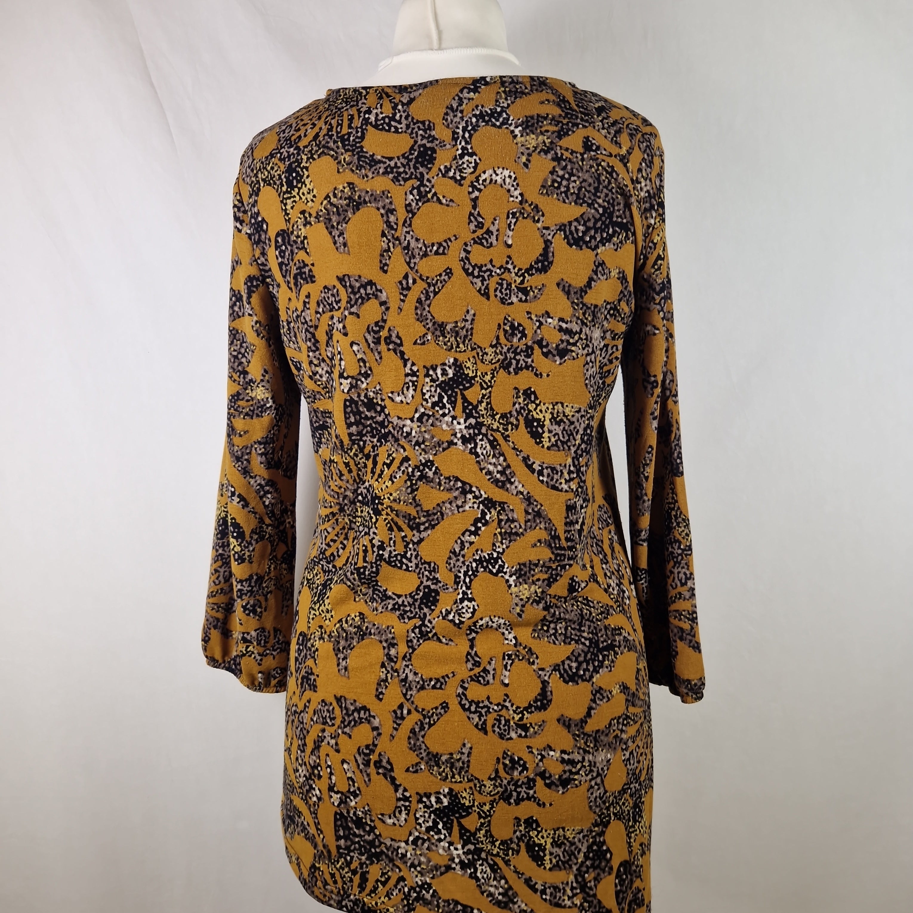 Patterned dress on a mannequin against a white background