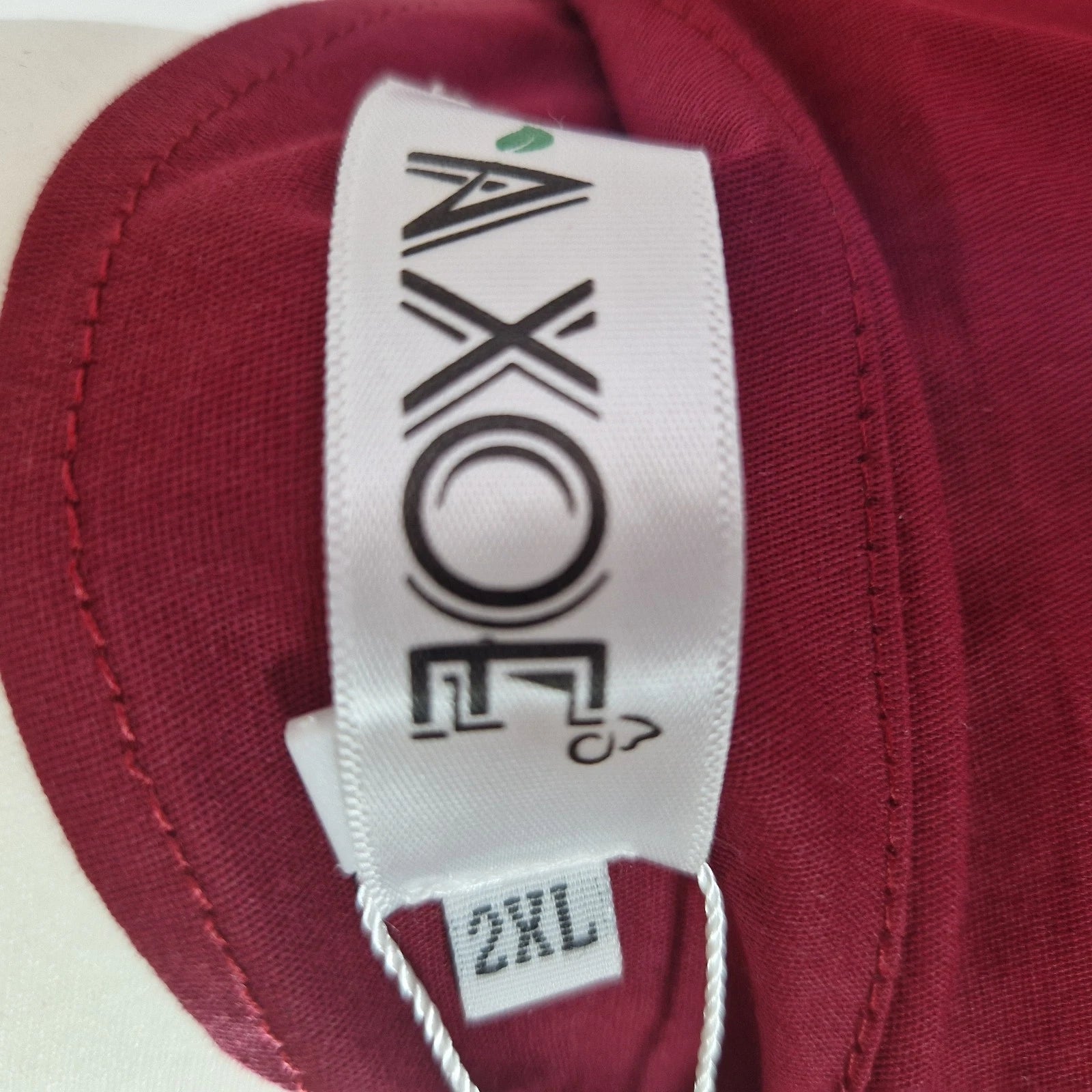 A close-up of a red Axoe brand dress tag showing a size 2XL label.