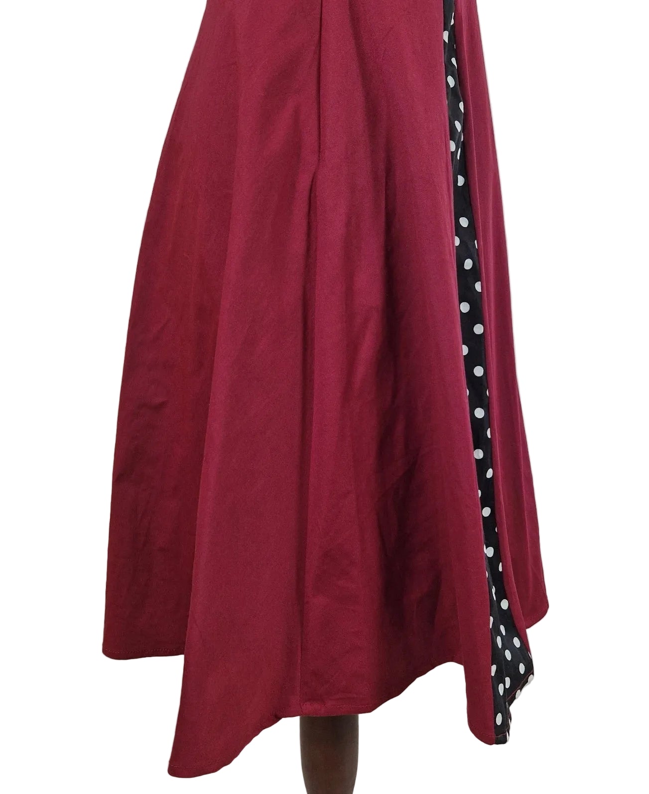 A sleeveless red A-line midi dress featuring a black and white polka dot side panel.
