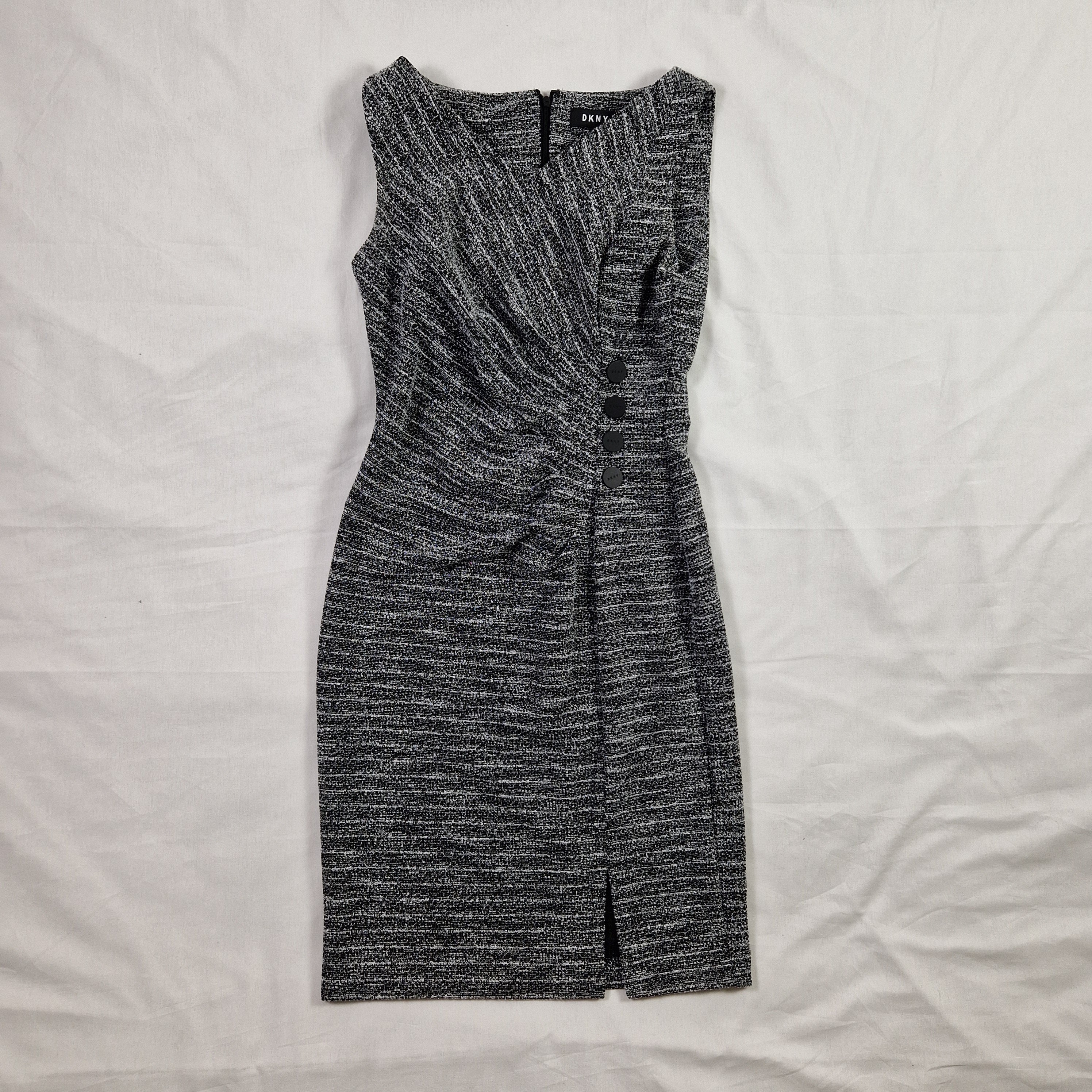 Folded gray pants on a white bedspread