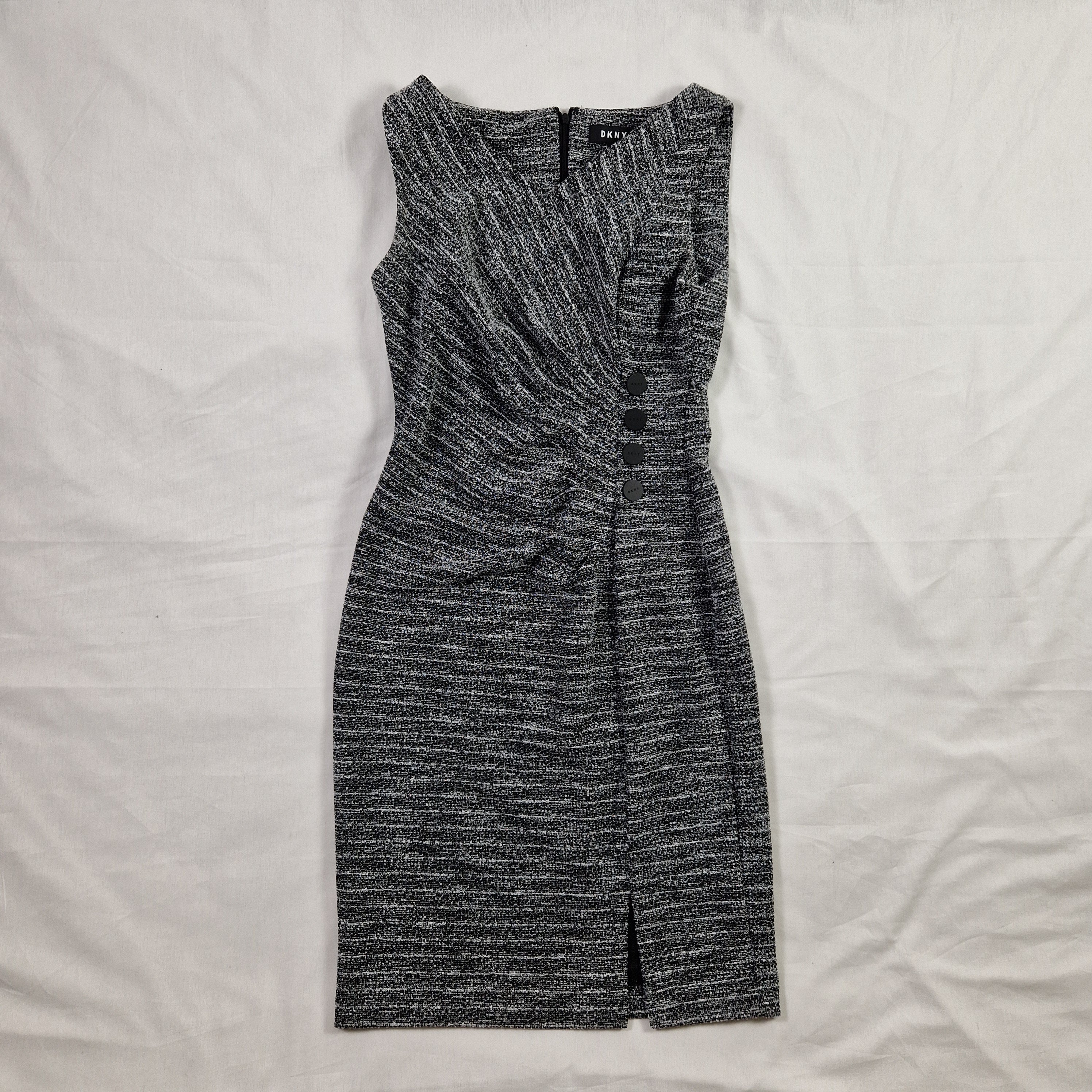Folded gray pants on a white bedspread