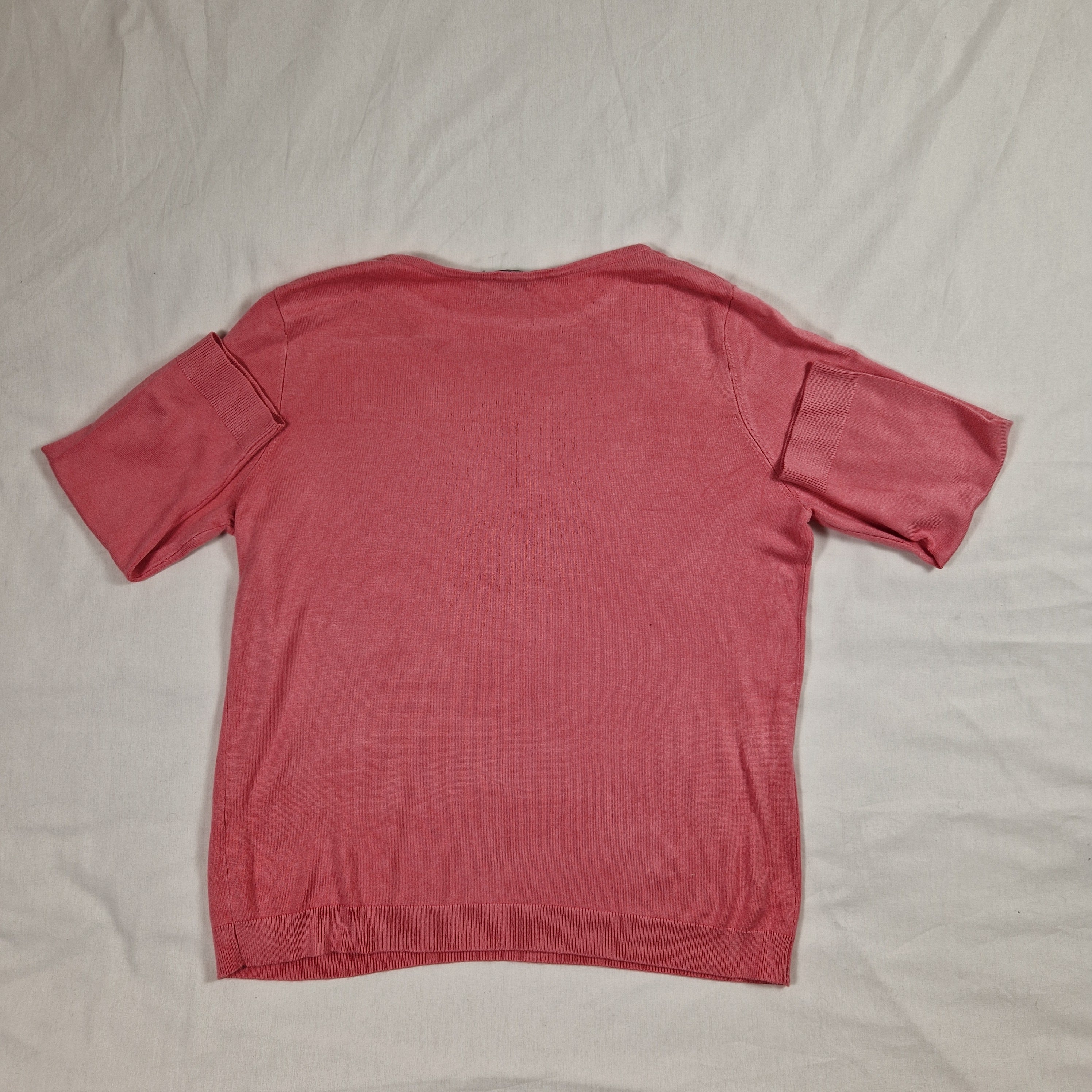 Pink long-sleeve shirt on a light gray background