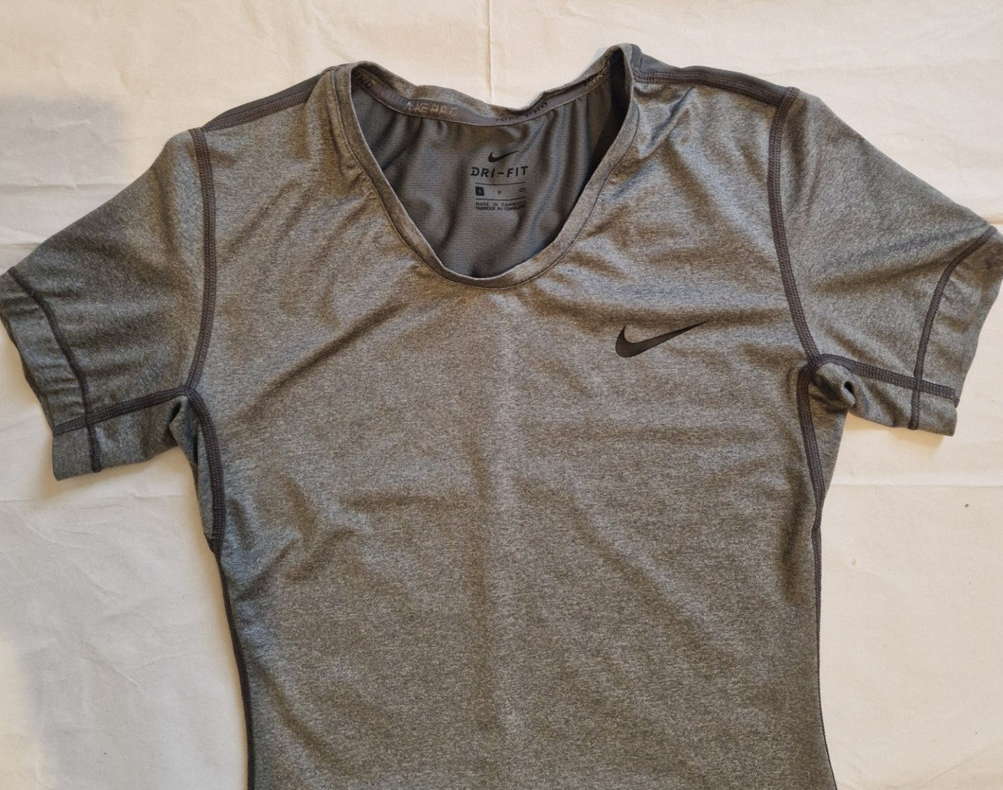 A grey Nike women's Dri-FIT short-sleeve training t-shirt with a crew neckline.