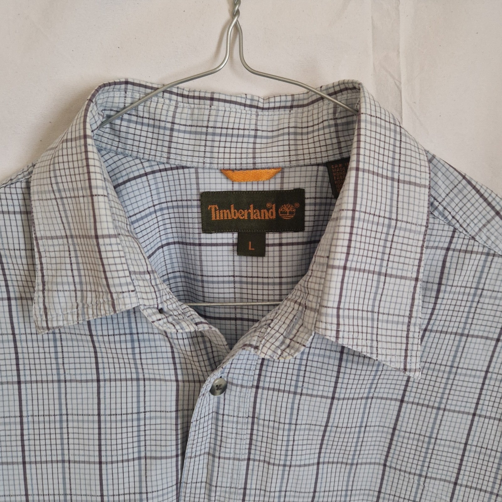 A Timberland men's long-sleeve shirt in a grey and blue check pattern with a button-down collar.