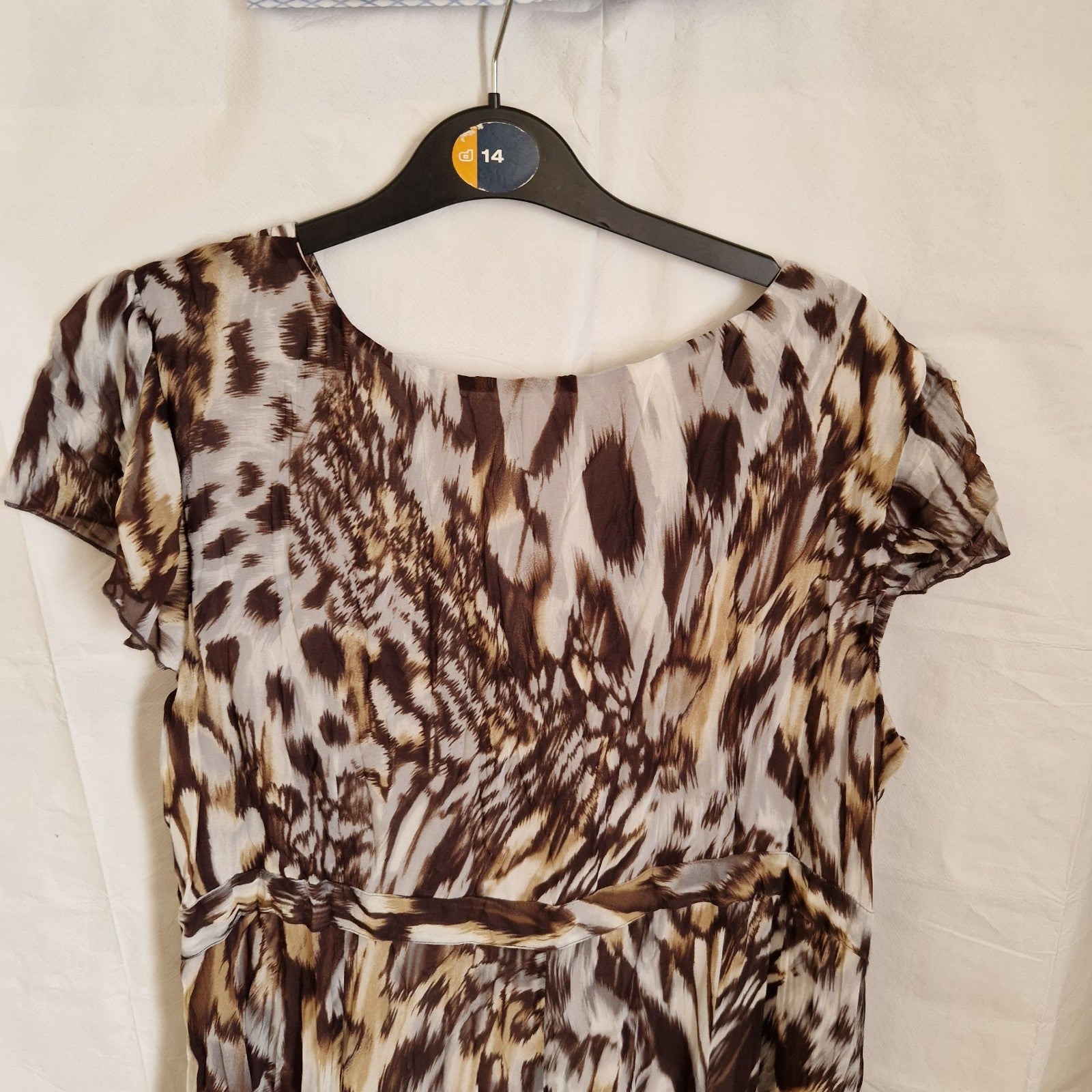 A brown and beige animal print chiffon maxi dress with short puff sleeves and a round neckline.