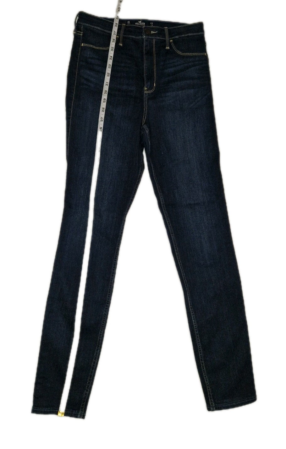 Hollister men's slim fit ultra high rise dark blue jeans with a measuring tape.