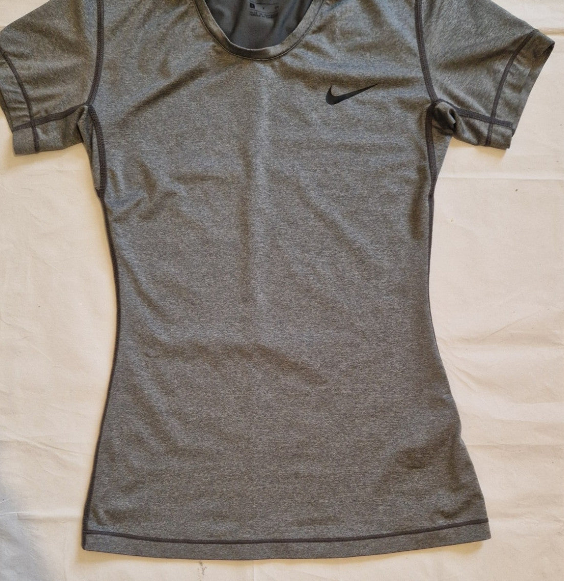 A grey Nike women's slim-fit short-sleeve training t-shirt with a crew neckline.