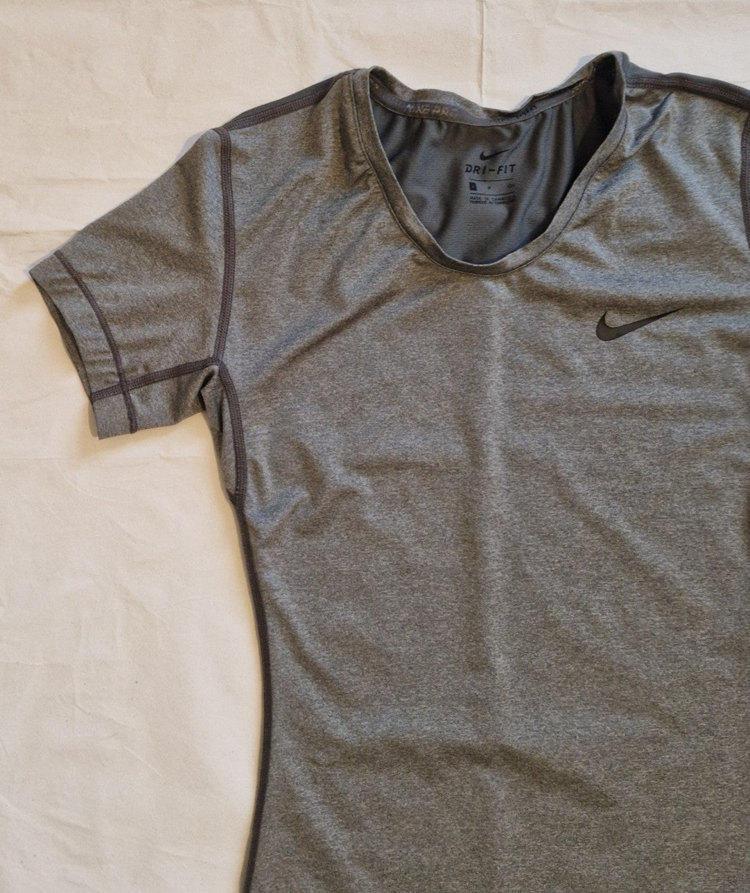 A grey Nike women's Dri-FIT short-sleeve training t-shirt with a crew neckline.