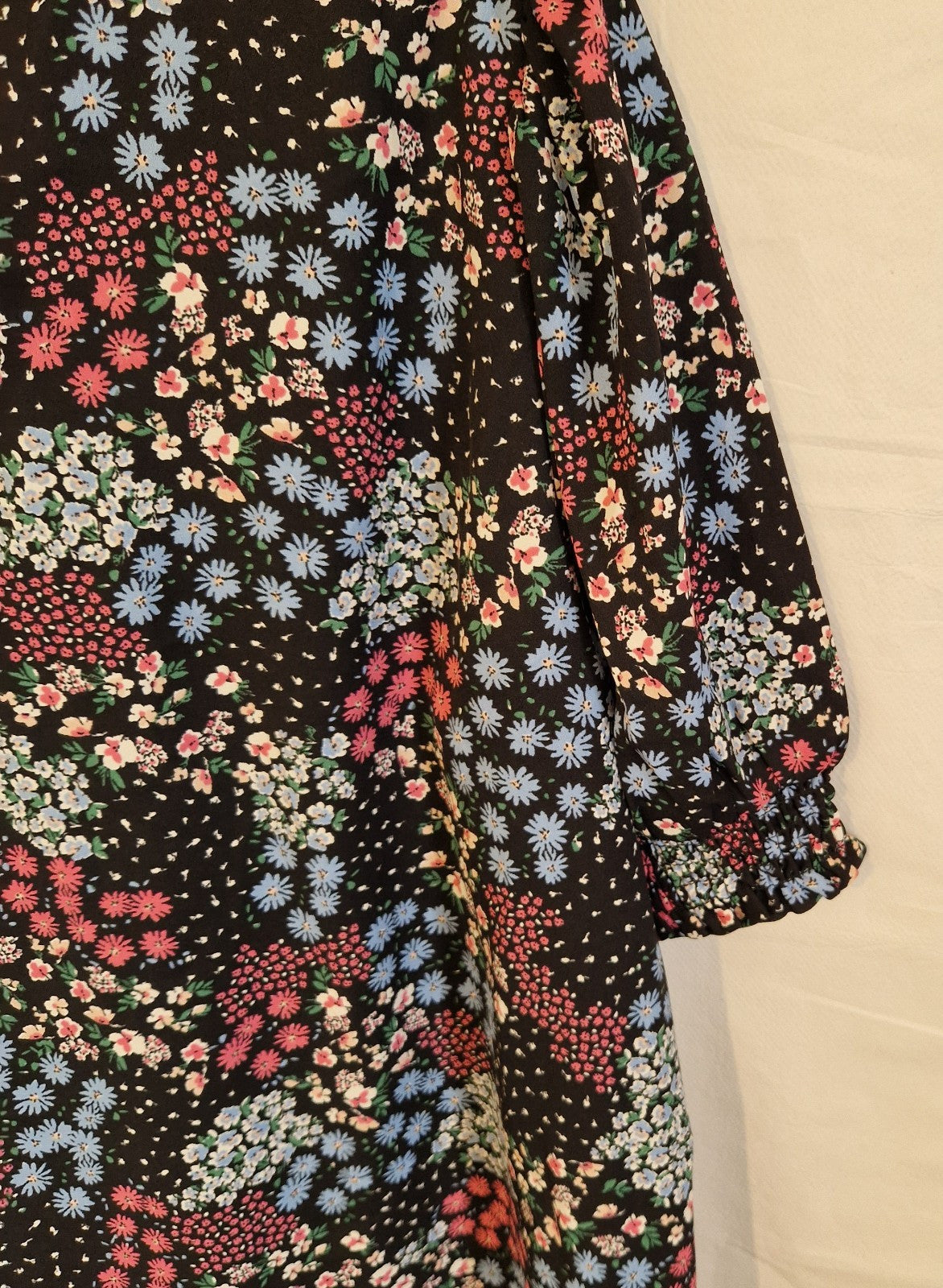 A black Cotton Traders blouse featuring a multicoloured floral print and short sleeves.