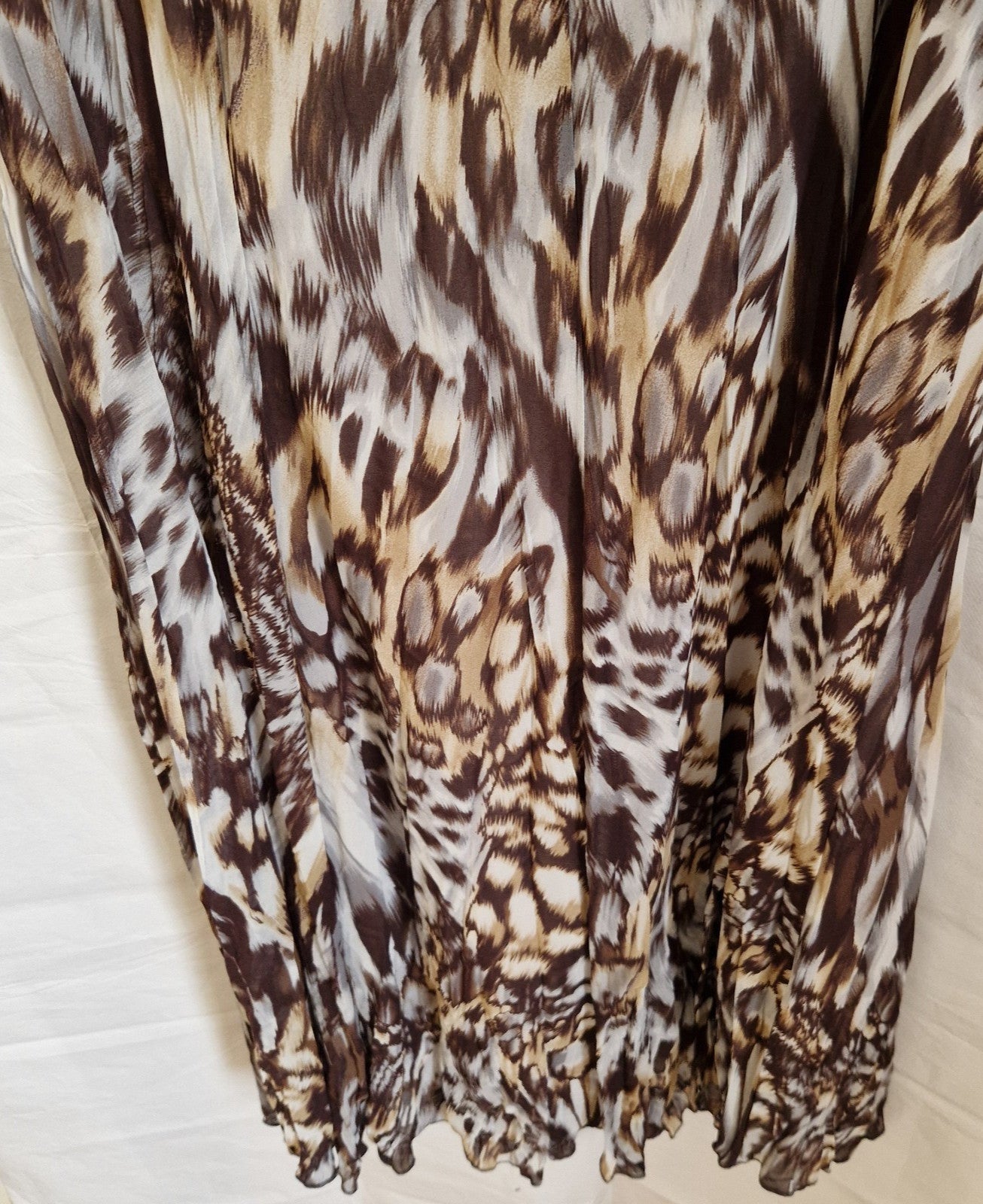 A brown and beige animal print chiffon maxi dress with a ruffled hem.
