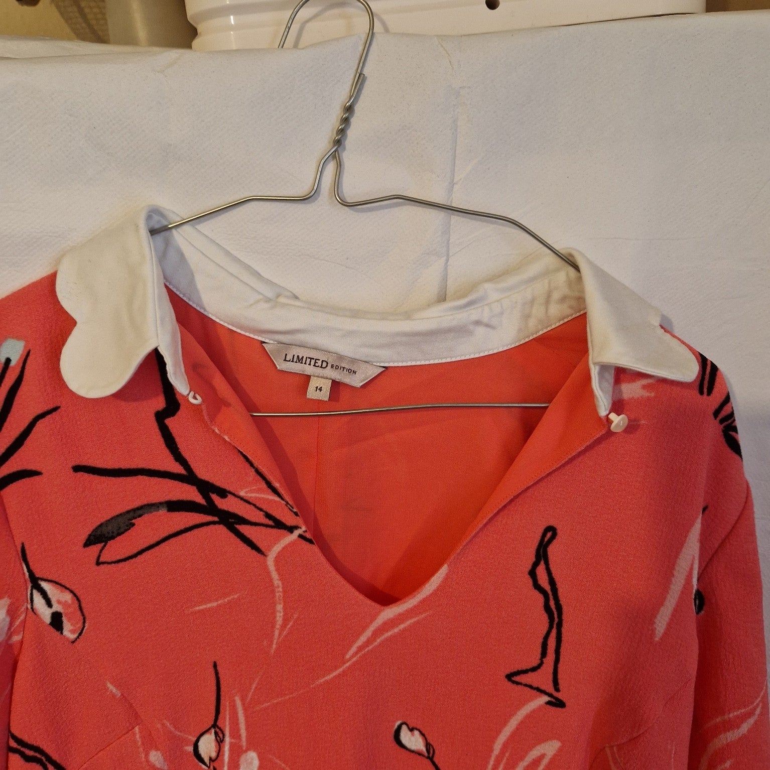 A pink floral fit and flare dress with a white scalloped collar and size 14 label.