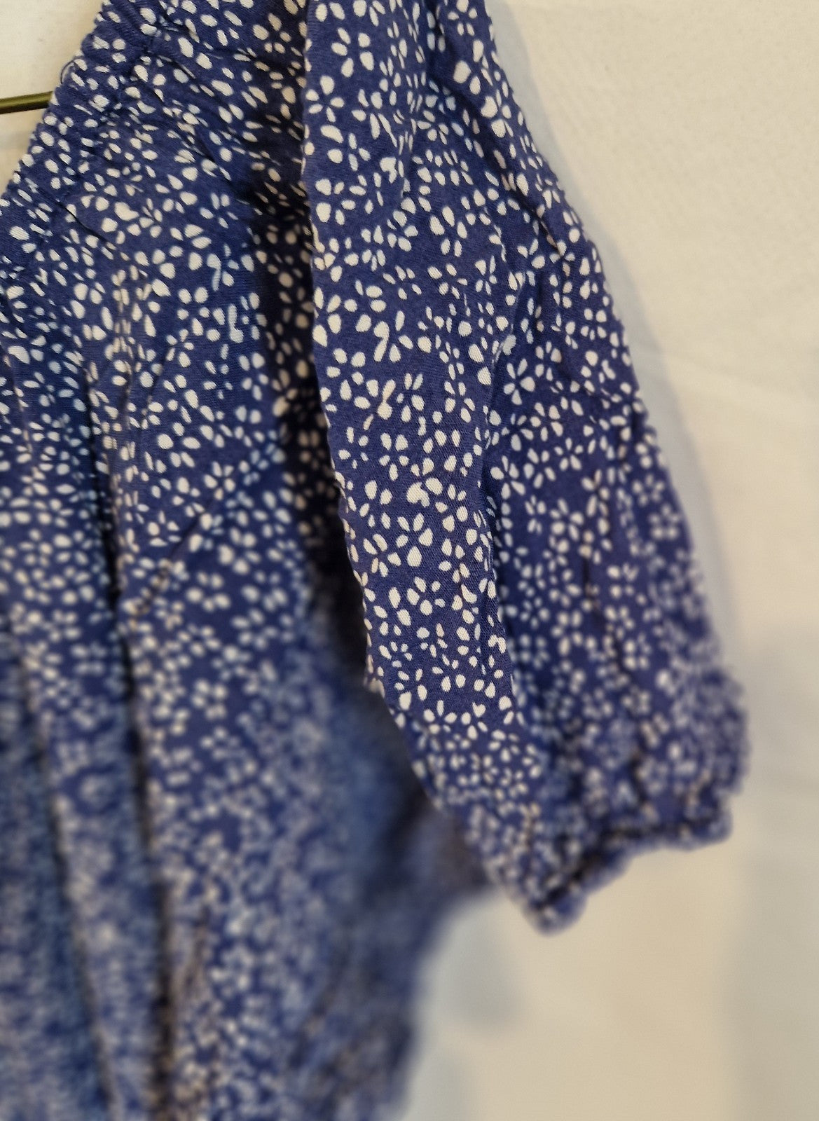A close-up view of the blue floral patterned short sleeve on a Leana Mode knee-length dress.