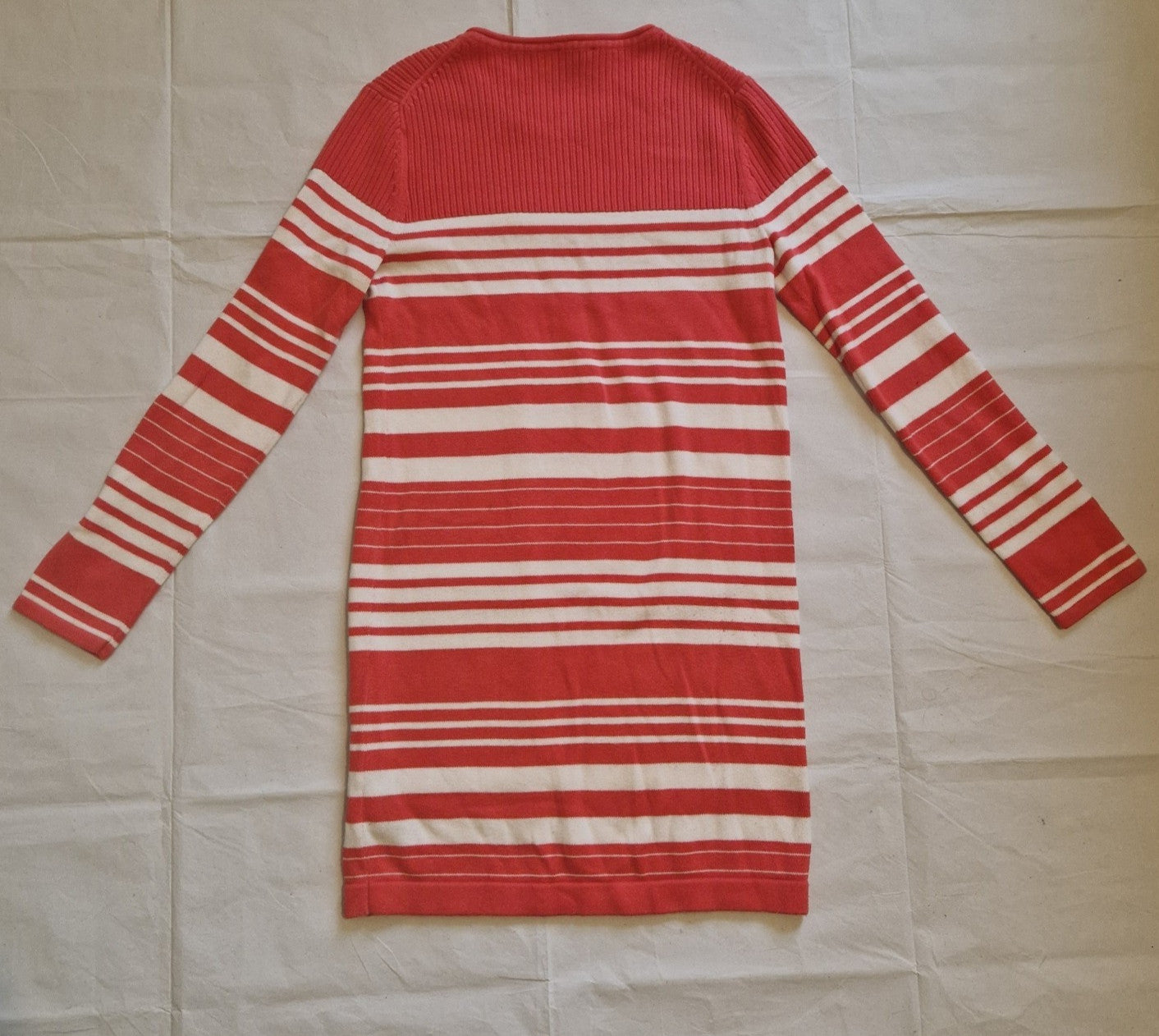 A red and white striped Tommy Hilfiger knitted jumper dress with long sleeves.