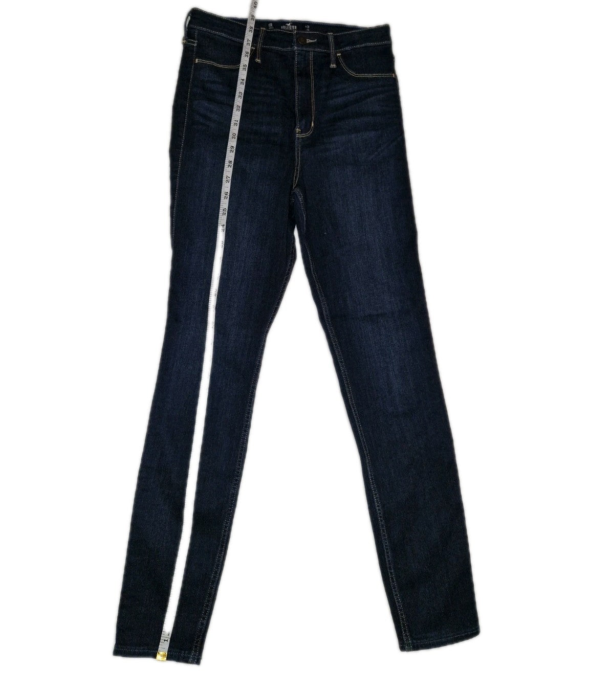 Hollister men's slim fit ultra high rise dark blue jeans with a measuring tape.