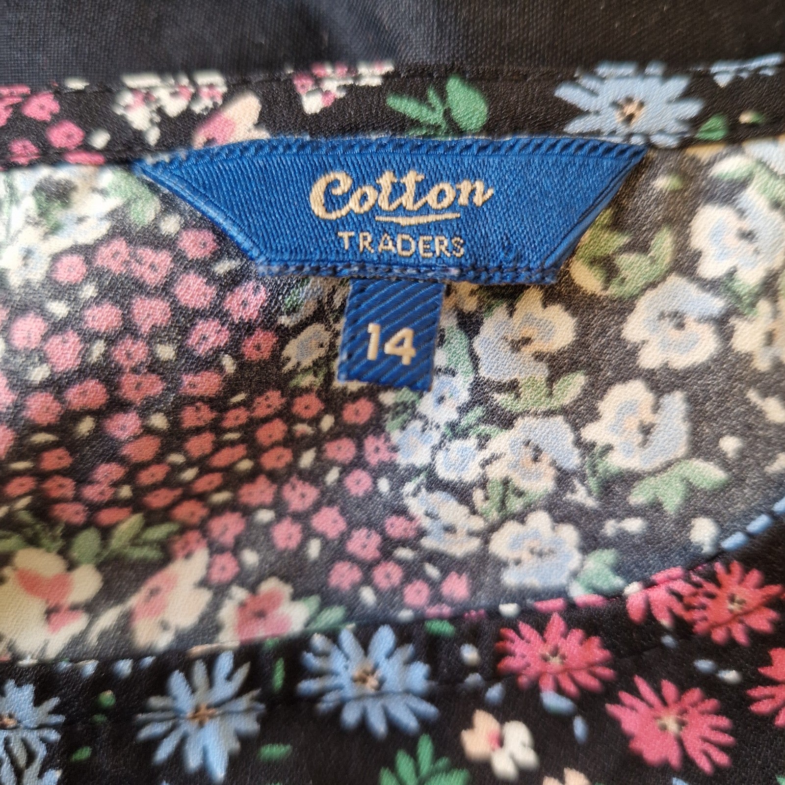 A Cotton Traders women's floral blouse in black with a size 14 tag.