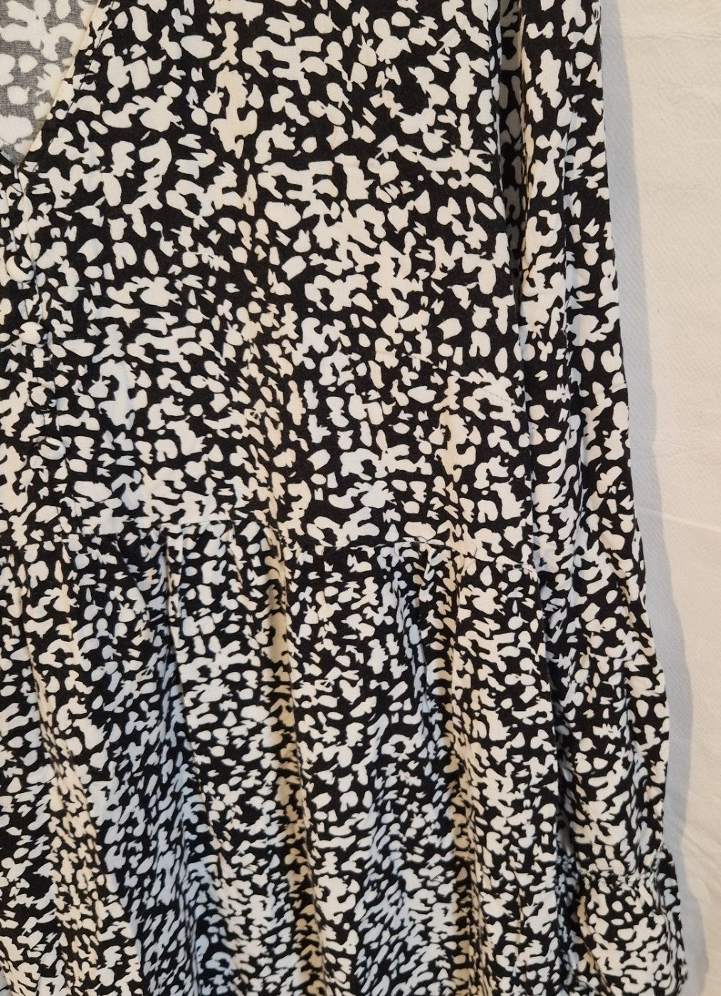 A black and white floral print midi dress featuring a V-neck and long puff sleeves.