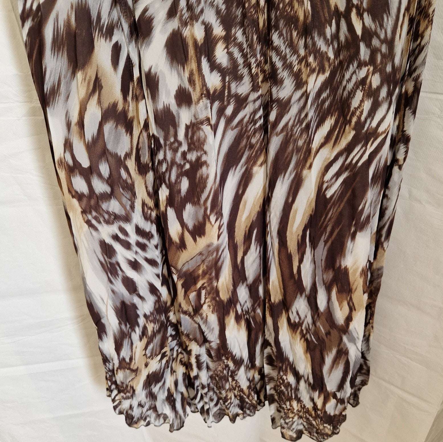 A brown and beige animal print chiffon maxi dress with a ruffled hem.