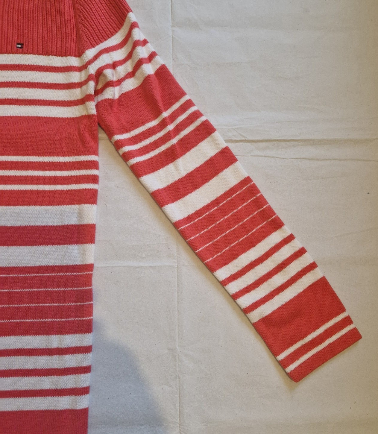 A red and white striped Tommy Hilfiger knitted jumper dress with long sleeves.
