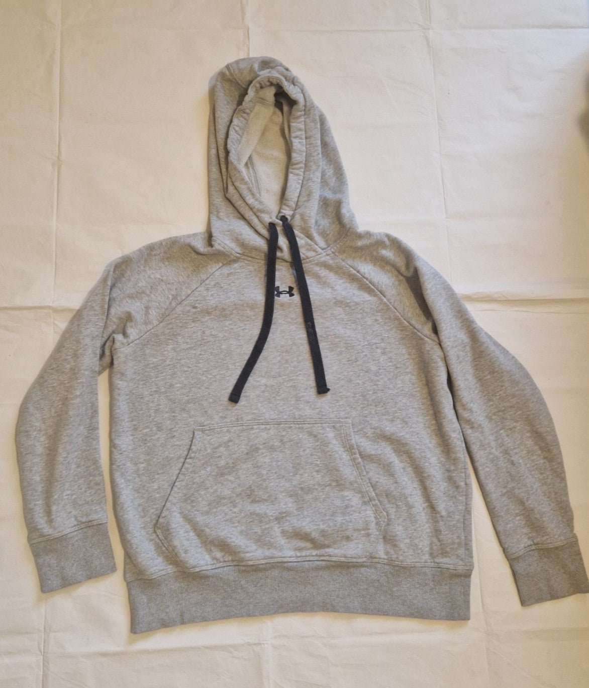 Grey Under Armour pullover hoodie with a front logo and long sleeves.