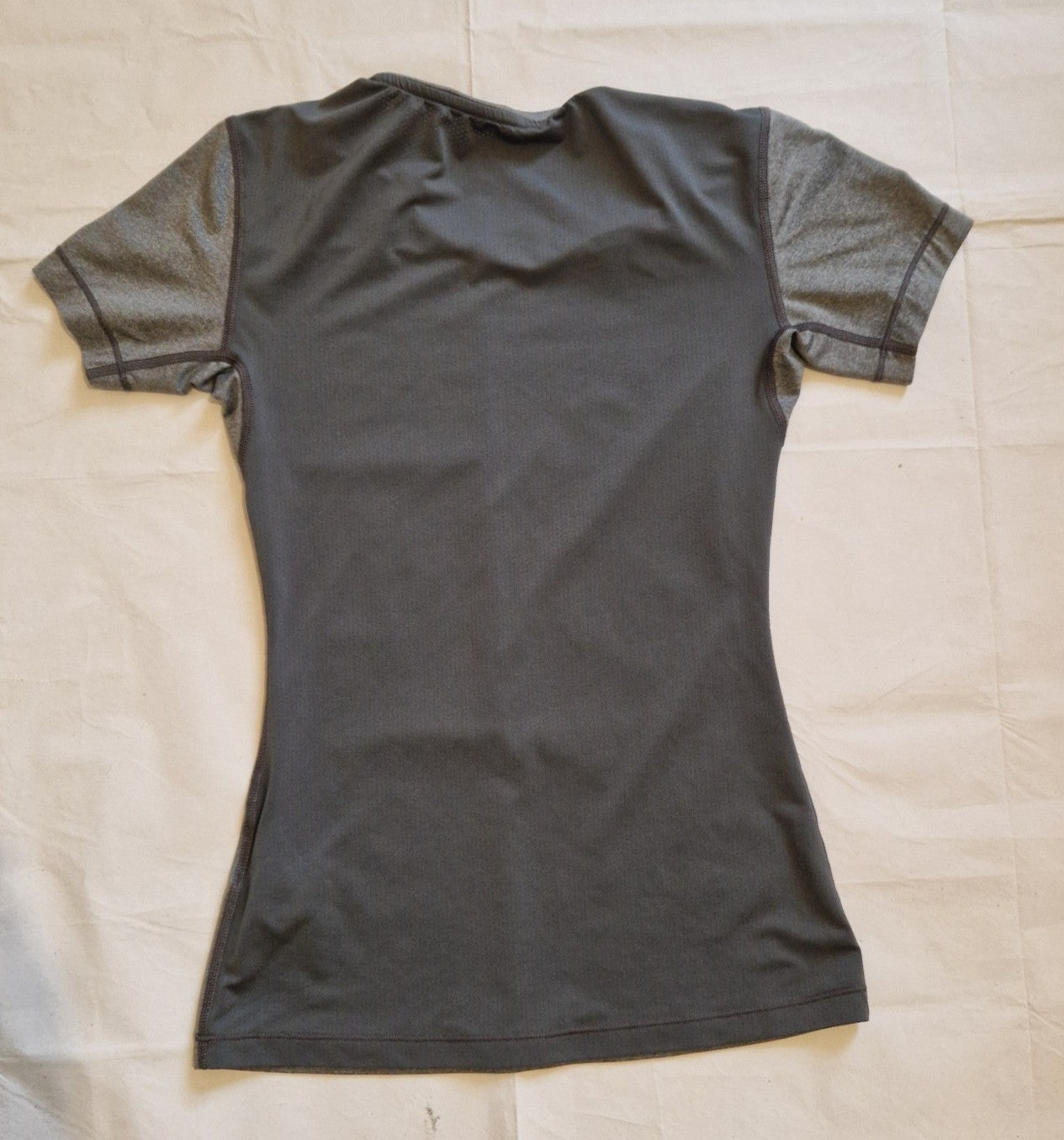 A grey Nike women's slim-fit short-sleeve training t-shirt with a crew neckline.
