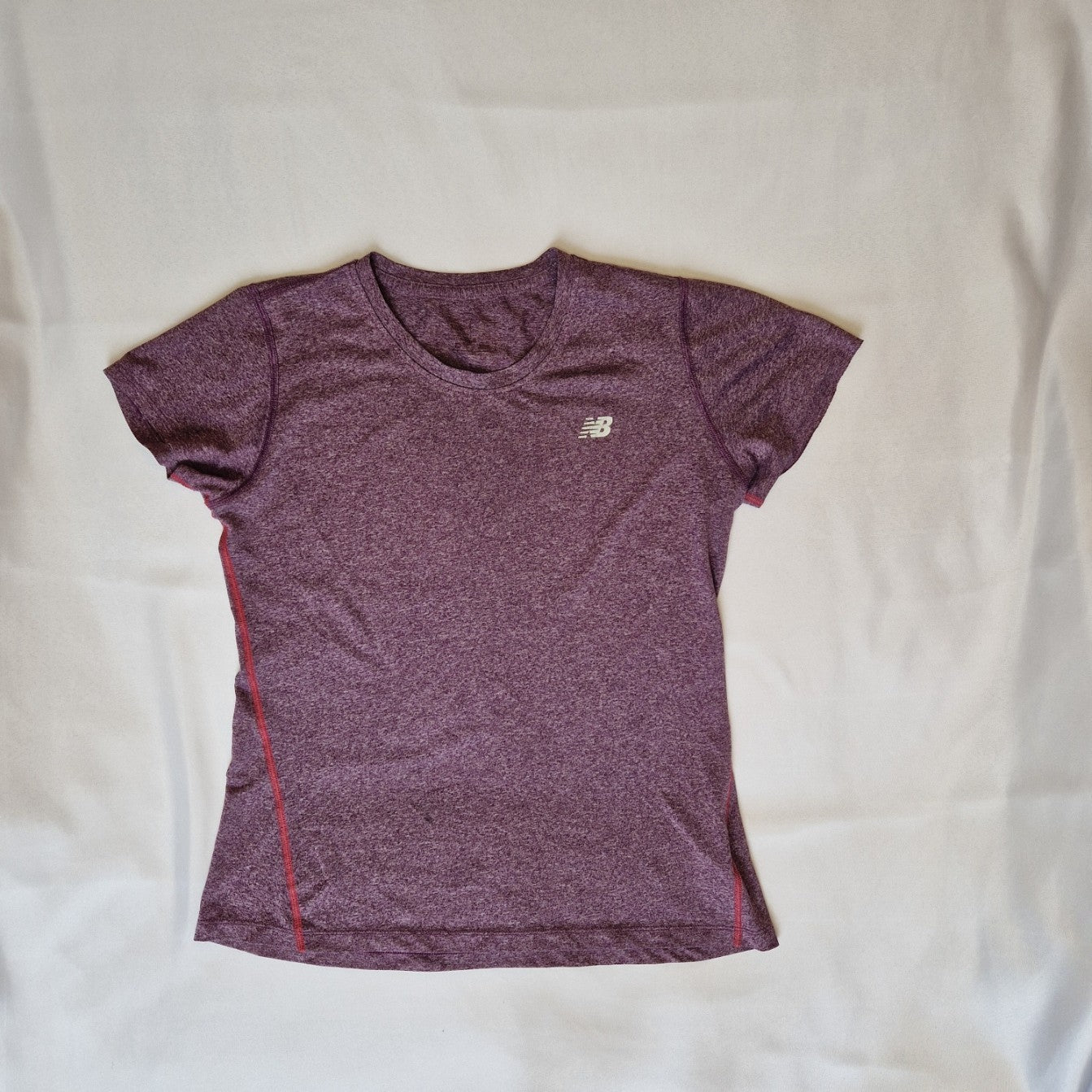 A purple New Balance women's short-sleeve running t-shirt with a round neck and athletic fit.