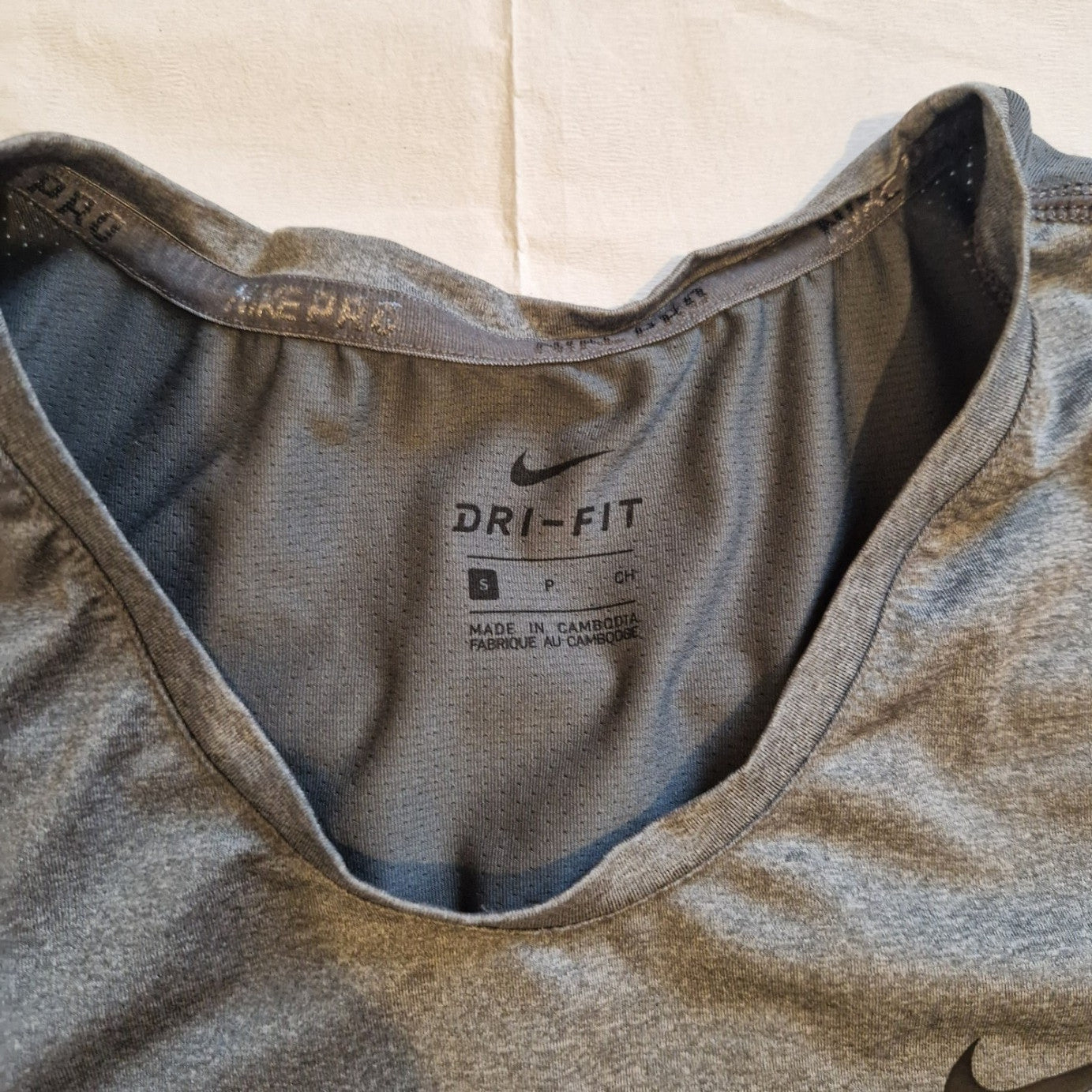 A grey Nike Dri-FIT women's training t-shirt with a crew neckline and size small label.