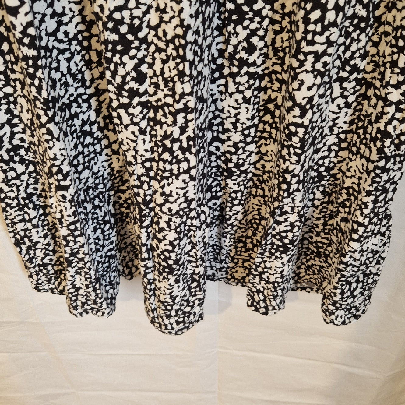 A black and white floral print midi dress with a ruffled hem.