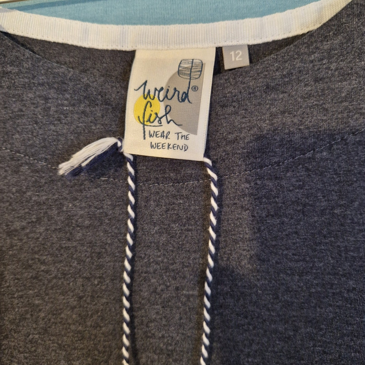 A grey Weird Fish brand label on a size 12 cotton blend midi dress with a round neckline.