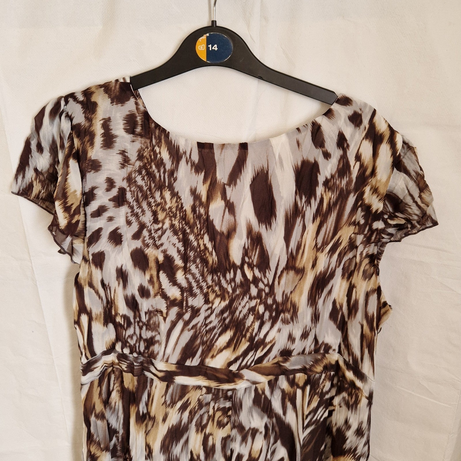 A brown and beige animal print chiffon maxi dress with short puff sleeves and a round neckline.